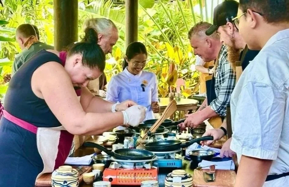 Group participating in an outdoor cooking class with Chef Nak at her private immersive cooking class in Phnom Penh