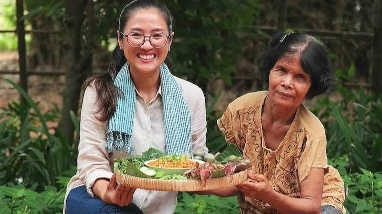 Chef Nak learning traditional Cambodian cooking techniques with an elderly villager.