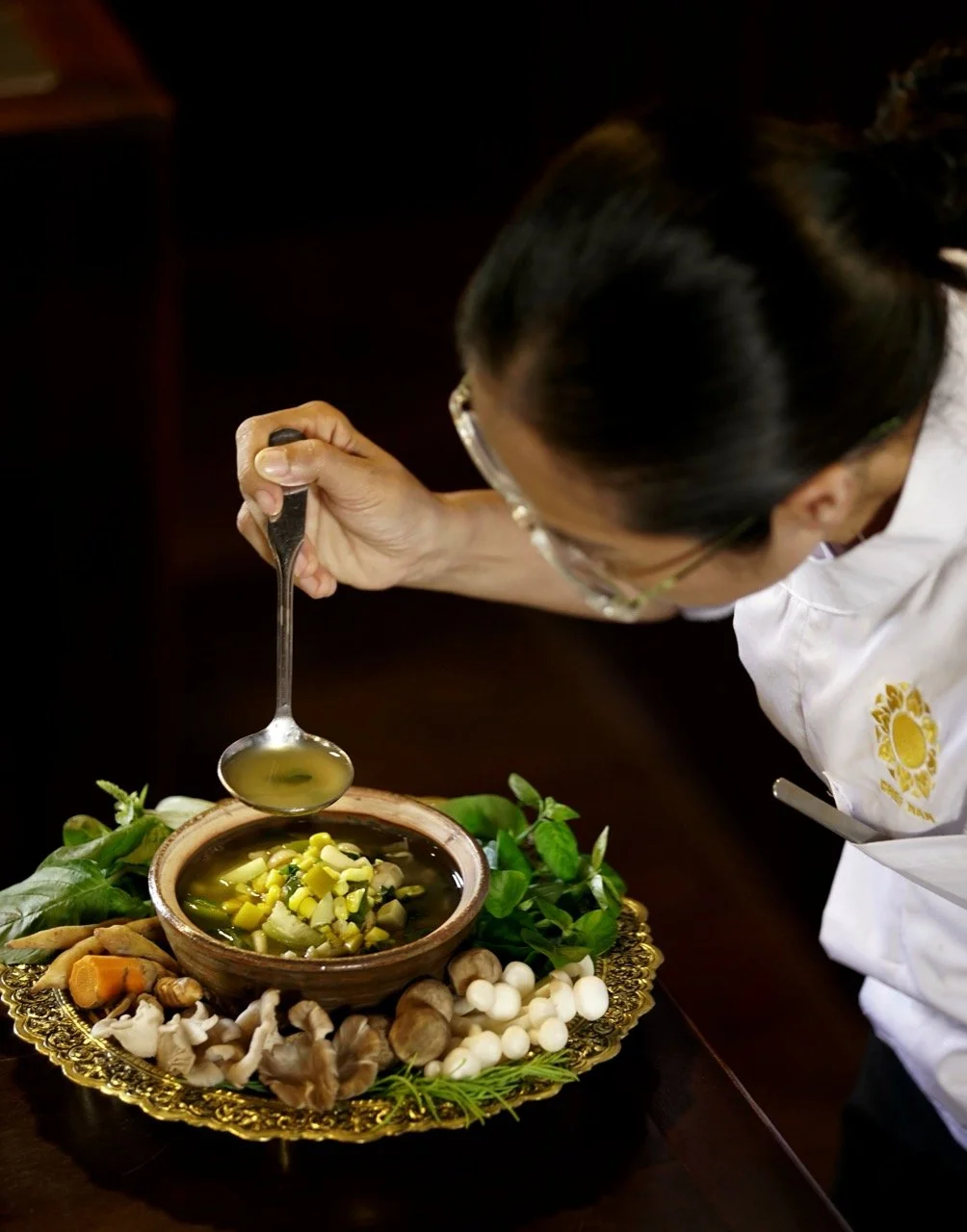 Chef Nak garnishing a traditional Cambodian village soup before serving
