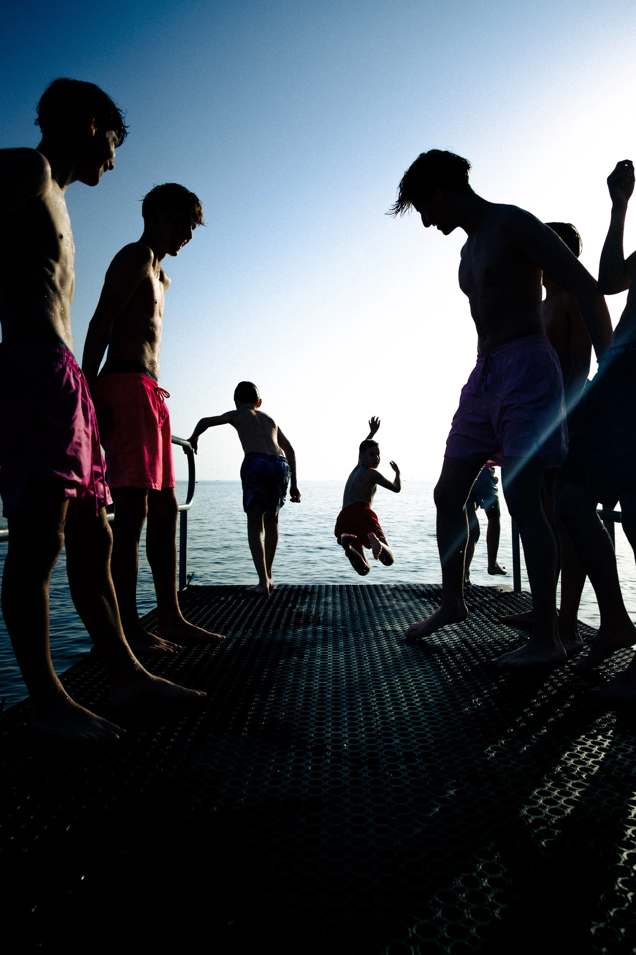 Des jeunes jouent sur le plongeoir de la plage de Lutry