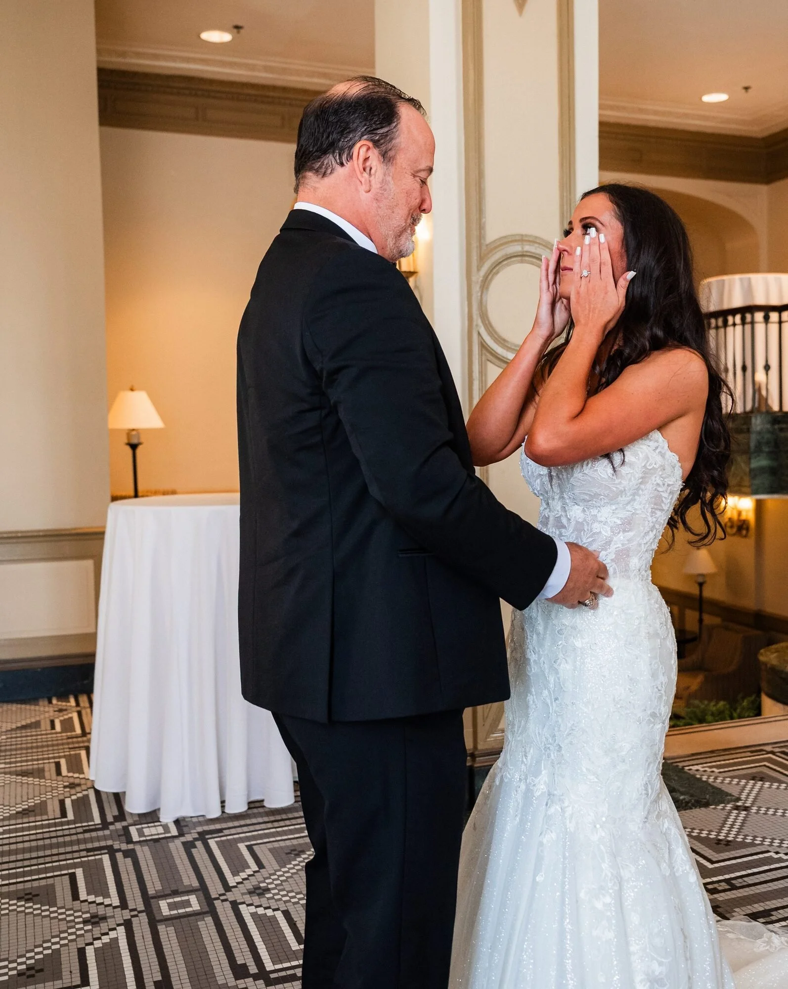 Bride wiping tears during a first look with her father at the Westin Poinsett