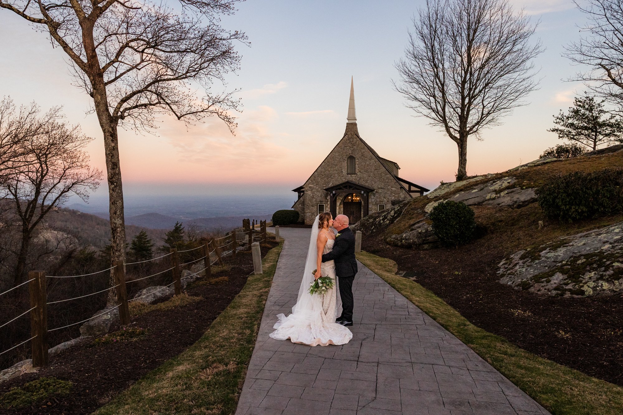 bride and groom kissing in front of chapel at sunset, photography by J Richard Photography