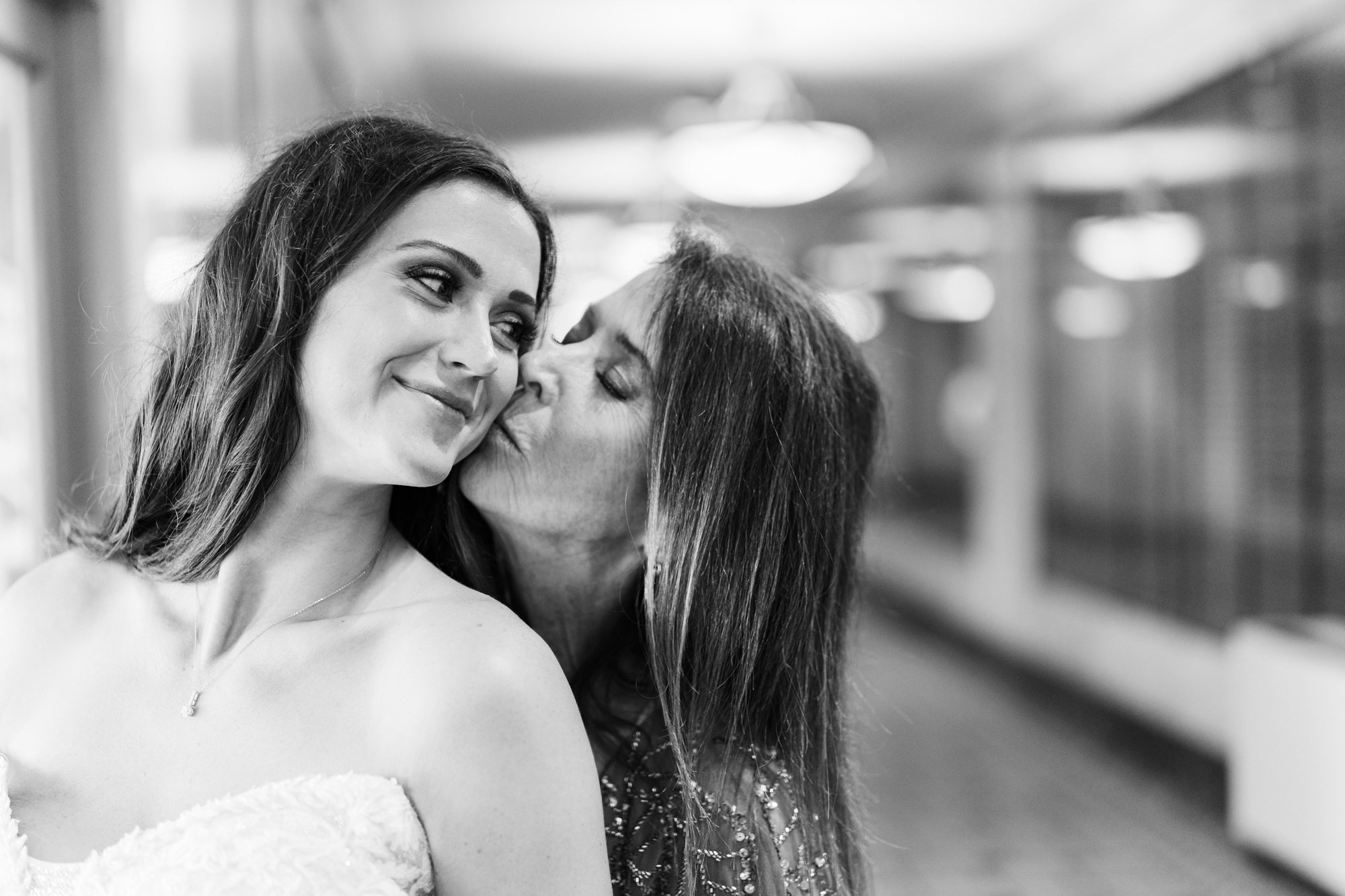 Mother of the bride kissing the bride's cheek while getting ready at the Westin Poinsett in Greenville, SC