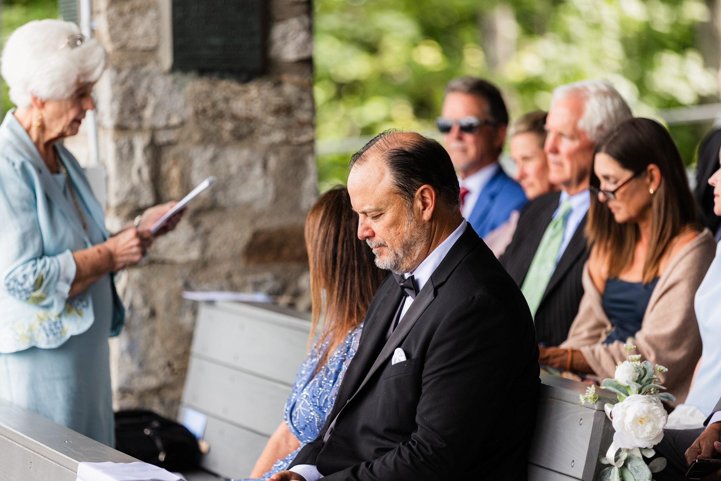 Grandmother giving a reading as the father of the bride listens at Pretty Place Chapel