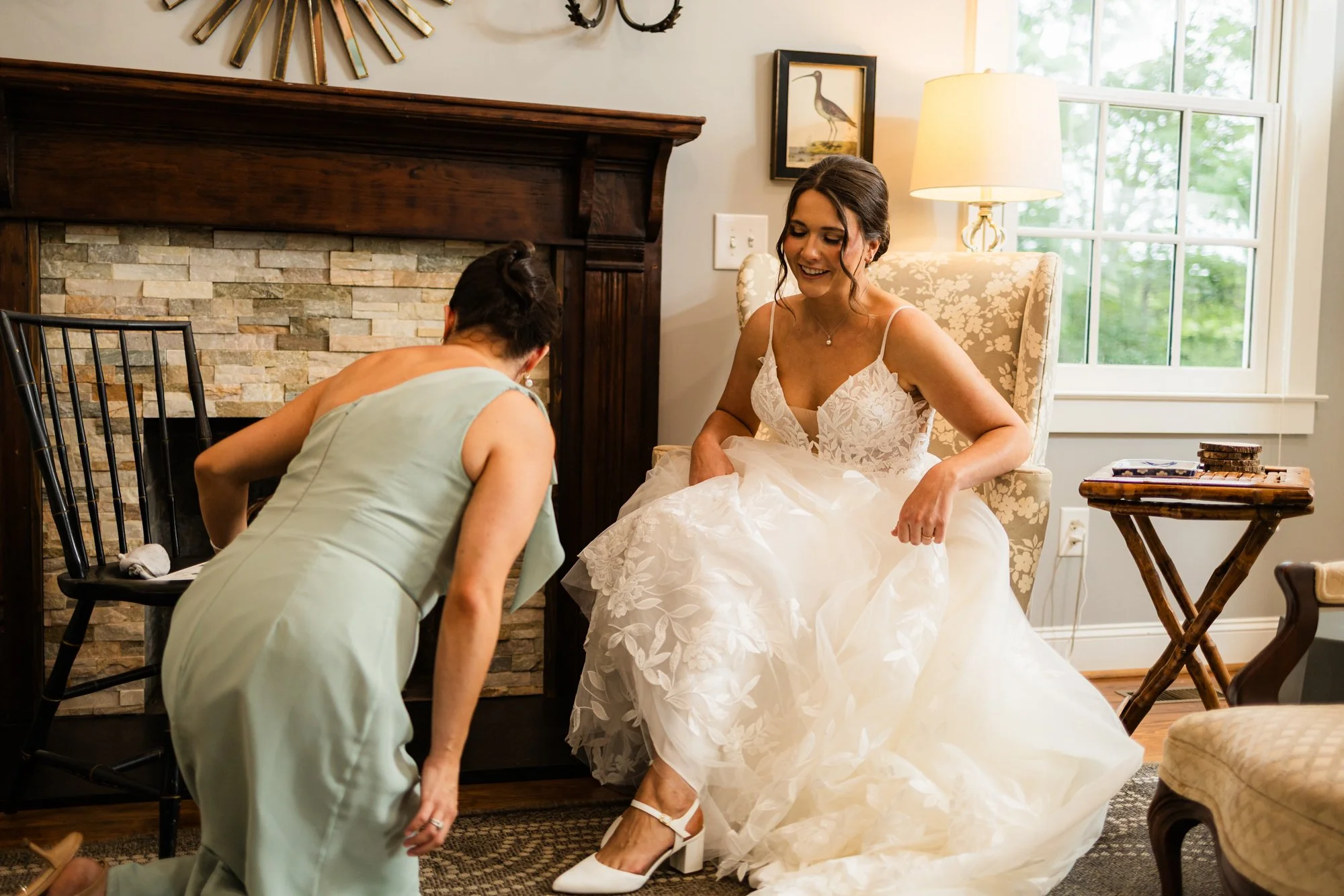 Matron of honor helping the bride with her shoes before a Sitton Hill Farm wedding in Easley, SC