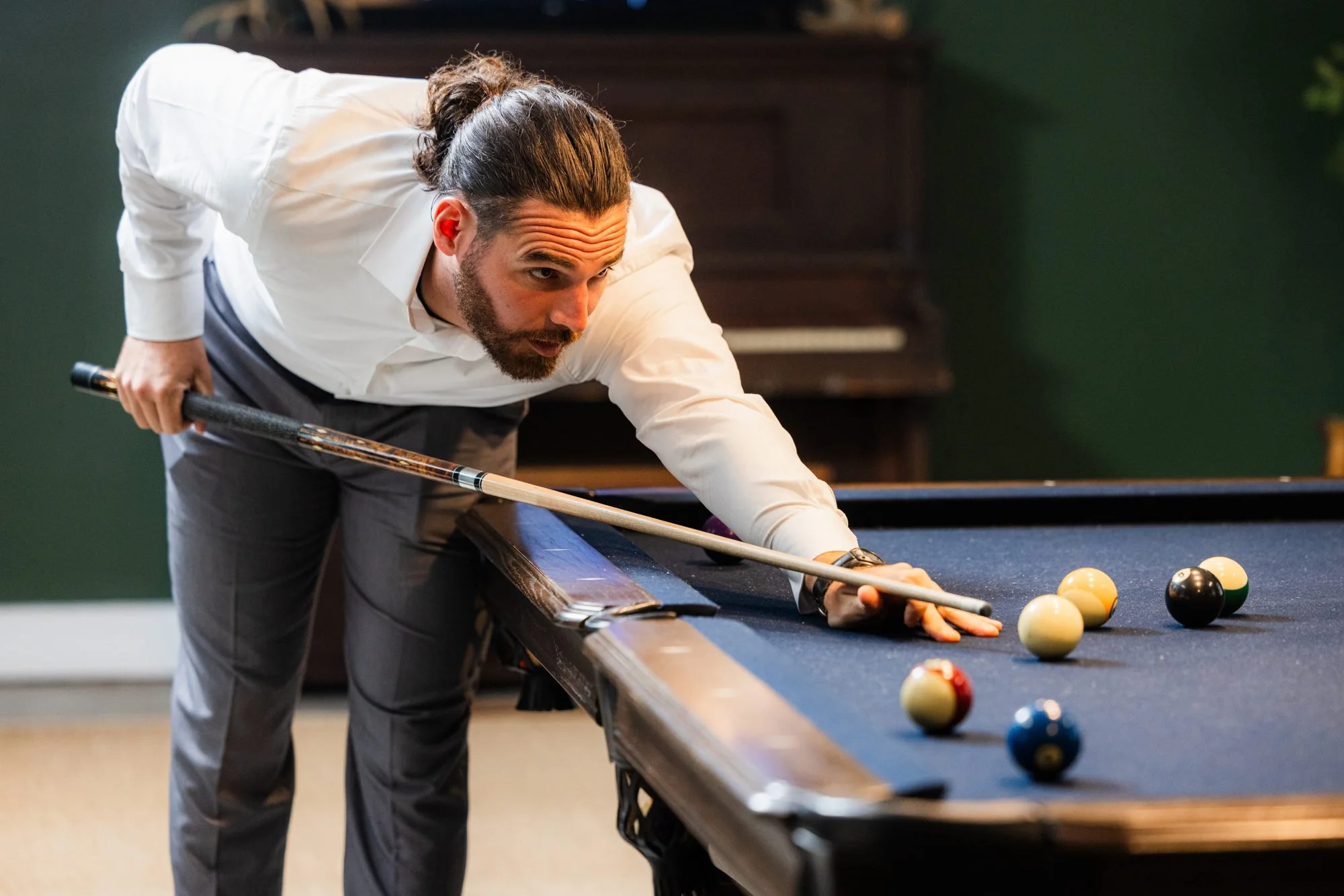 Groom lining up a pool shot while getting ready at Greenbrier Farms in Easley, SC