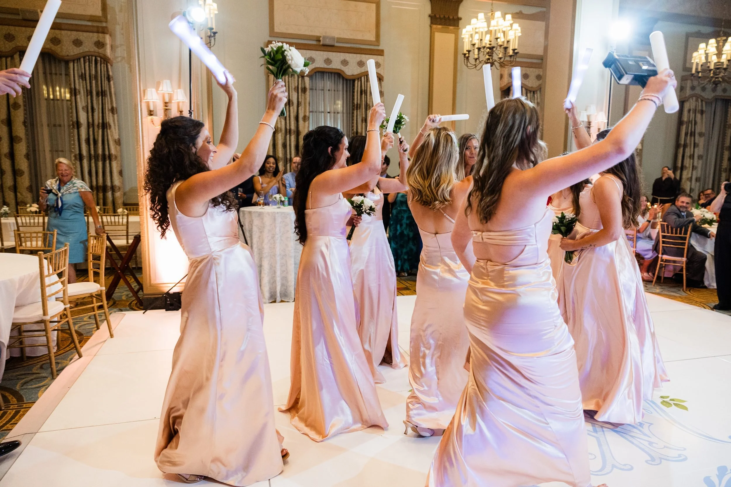 Bridesmaids dancing into the Westin Poinsett ballroom with light up sticks