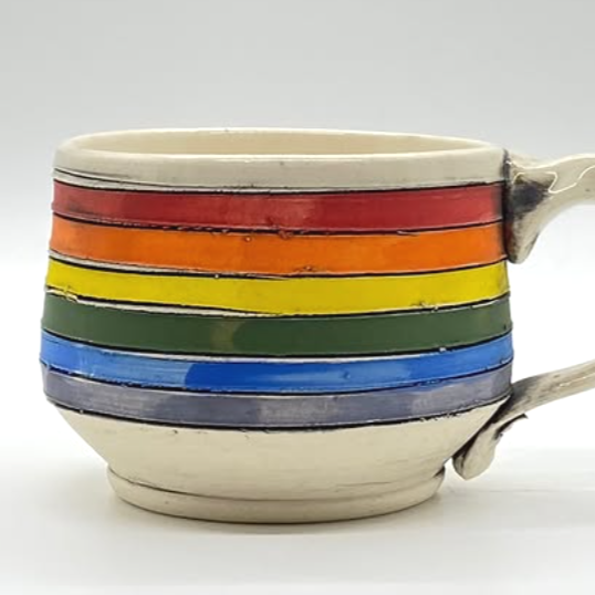 A ceramic cup with multiple painted rainbow-colored horizontal stripes.