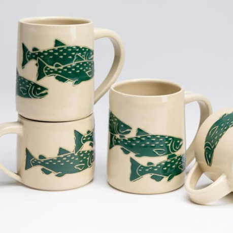 Stacked and arranged coffee mugs with a fish design.