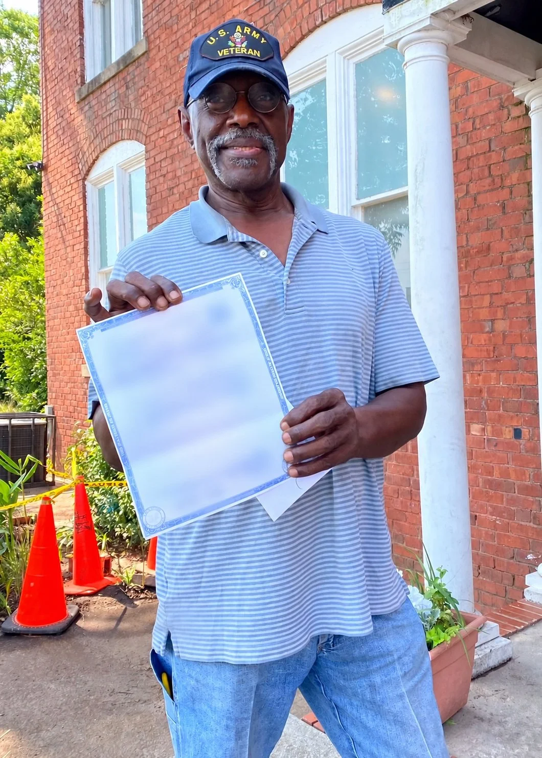 A man holds up a birth certificate outside GAP Ministries.