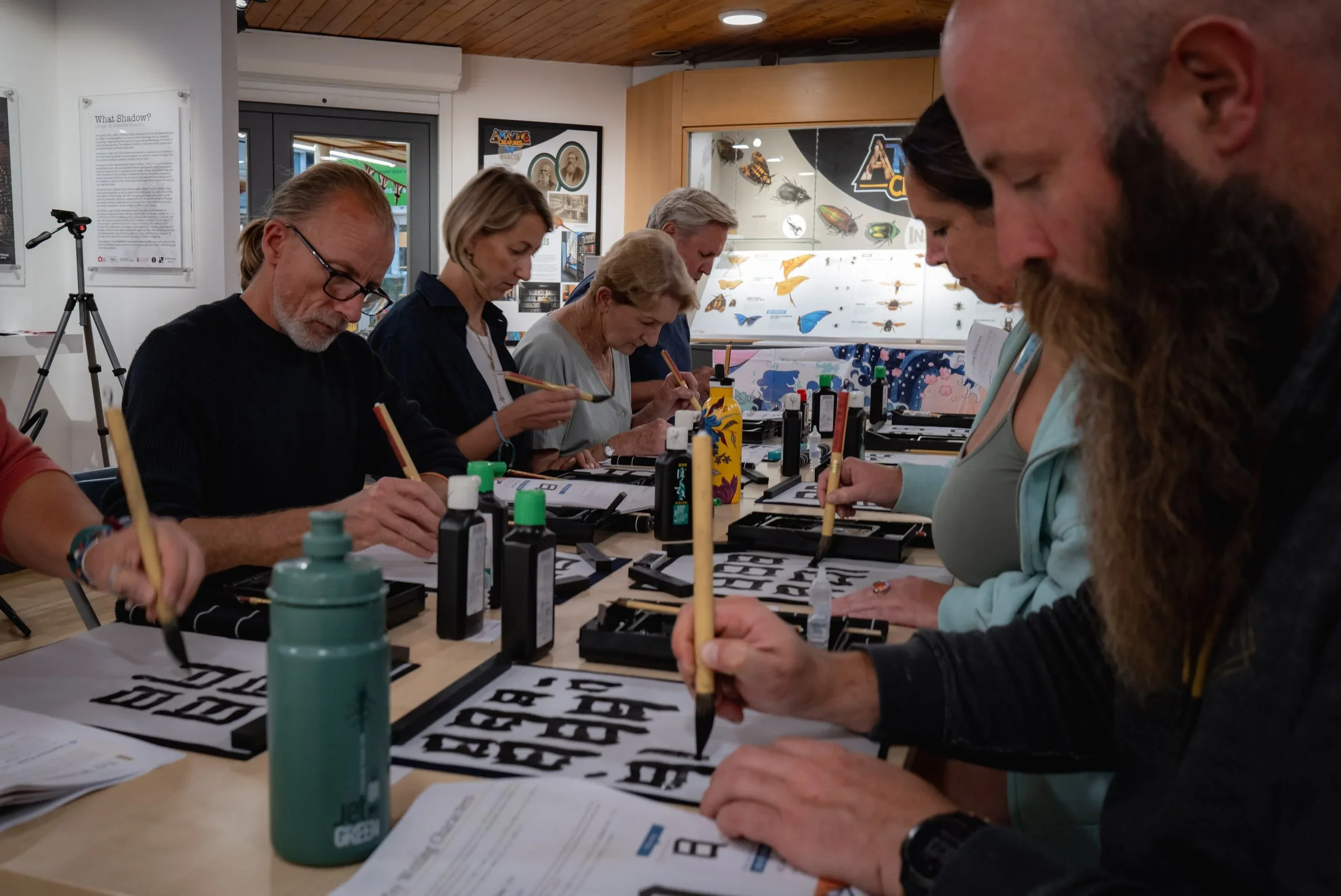 a group of people learning Japanese calligraphy