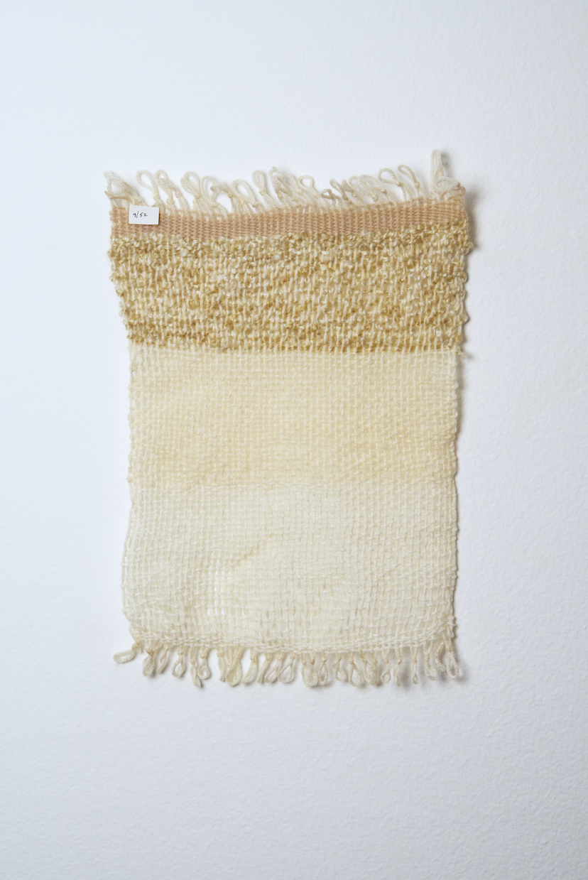 Neutral shades of white, tan, gold, brown, black and orange yarn to provide a visual record of the shift in feelings from week to week over the course of one year.