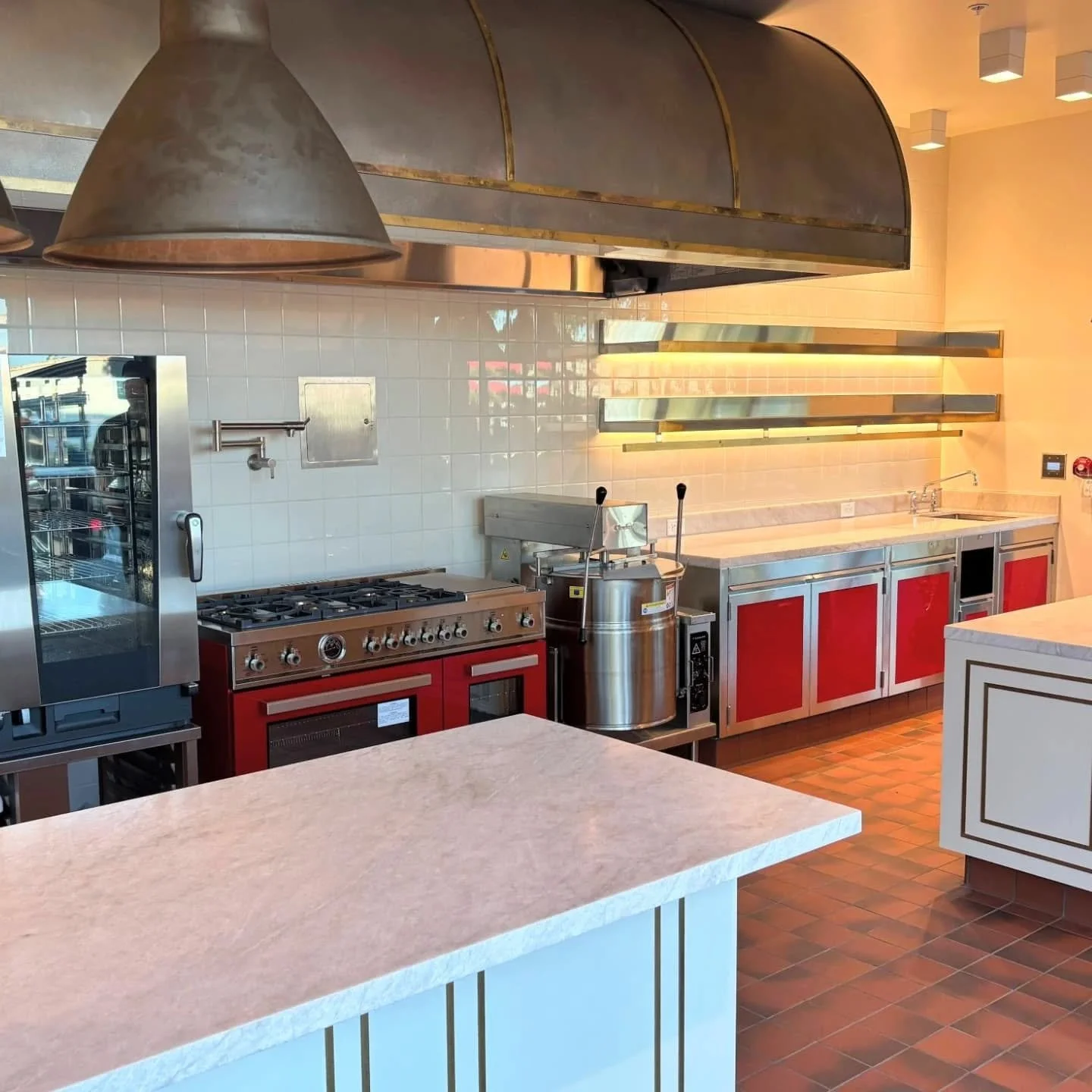 The Mezzetta test kitchen is complete! 🍴✨ We are proud to showcase this fully custom space featuring powder coated and stainless steel cabinetry, concealed bracket shelving with LED lighting, and elegant brass details throughout.