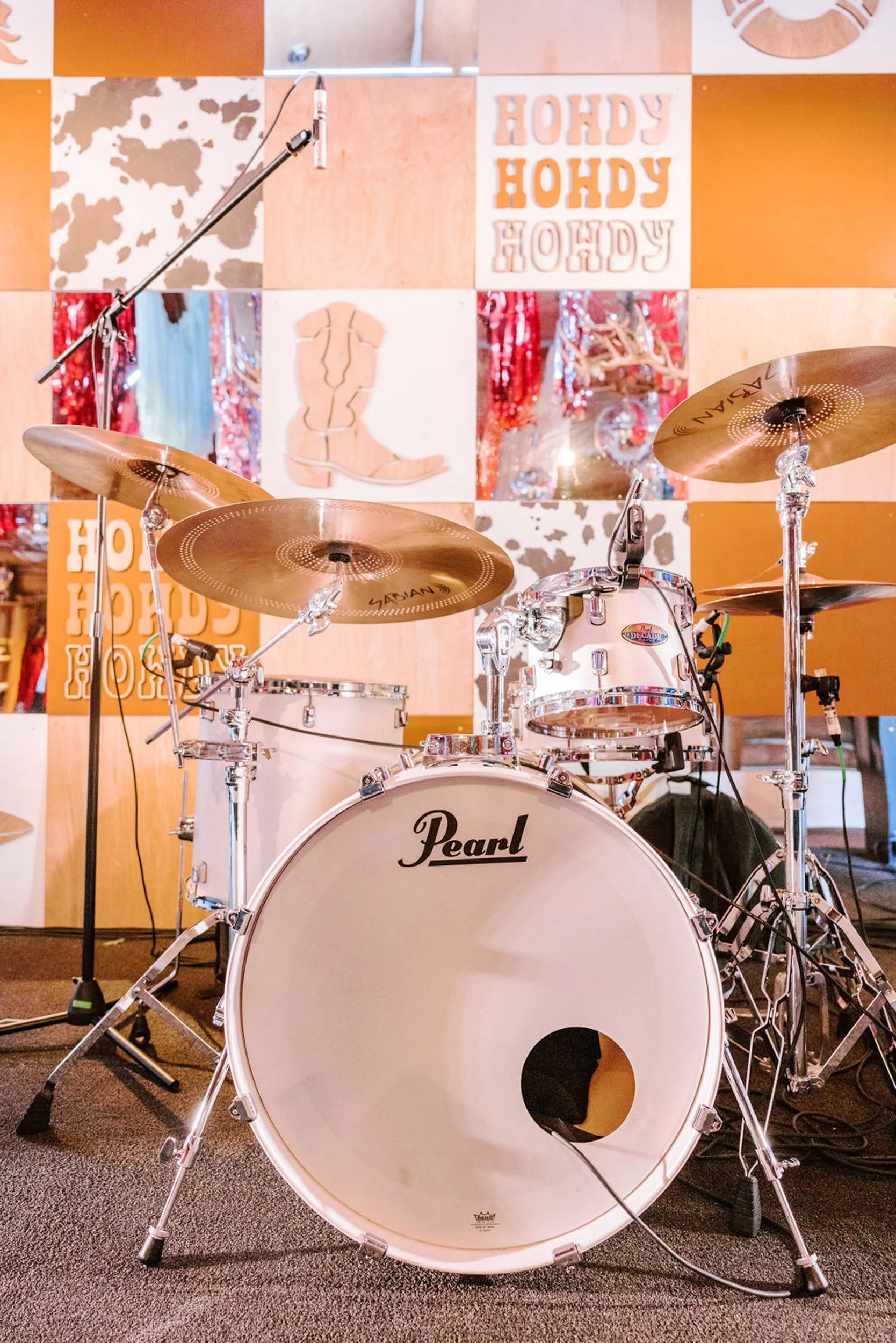 Live band drum set in Pine Creek Cookhouse wedding reception with Howdy menus visible on tables, entertainment at a rodeo disco wedding in Aspen Colorado
