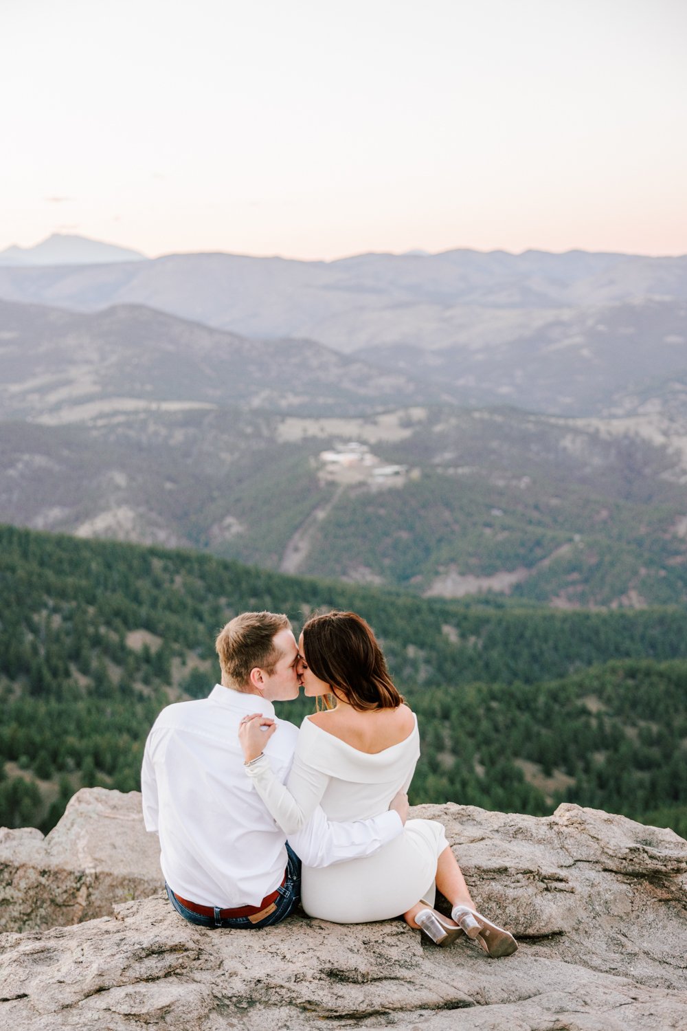 happy couple with mountains in the background during their engagement session in boulder, colorado