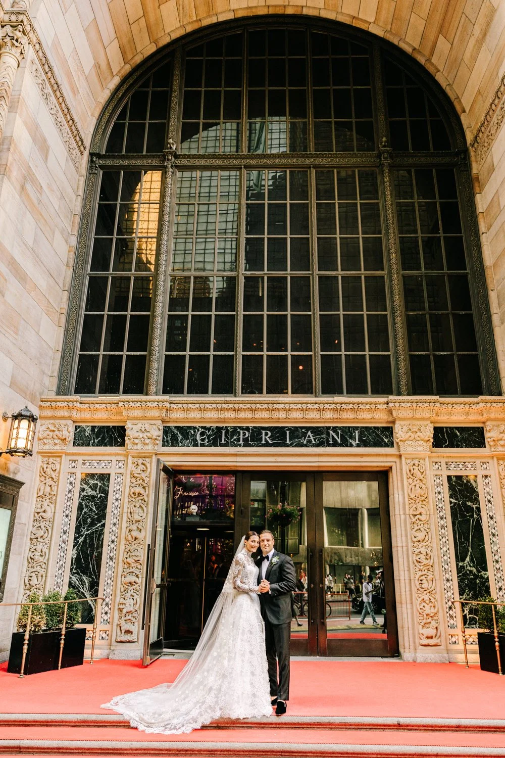 Bride and groom kissing in front of Cipriani 42nd Street in New York City on their wedding day
