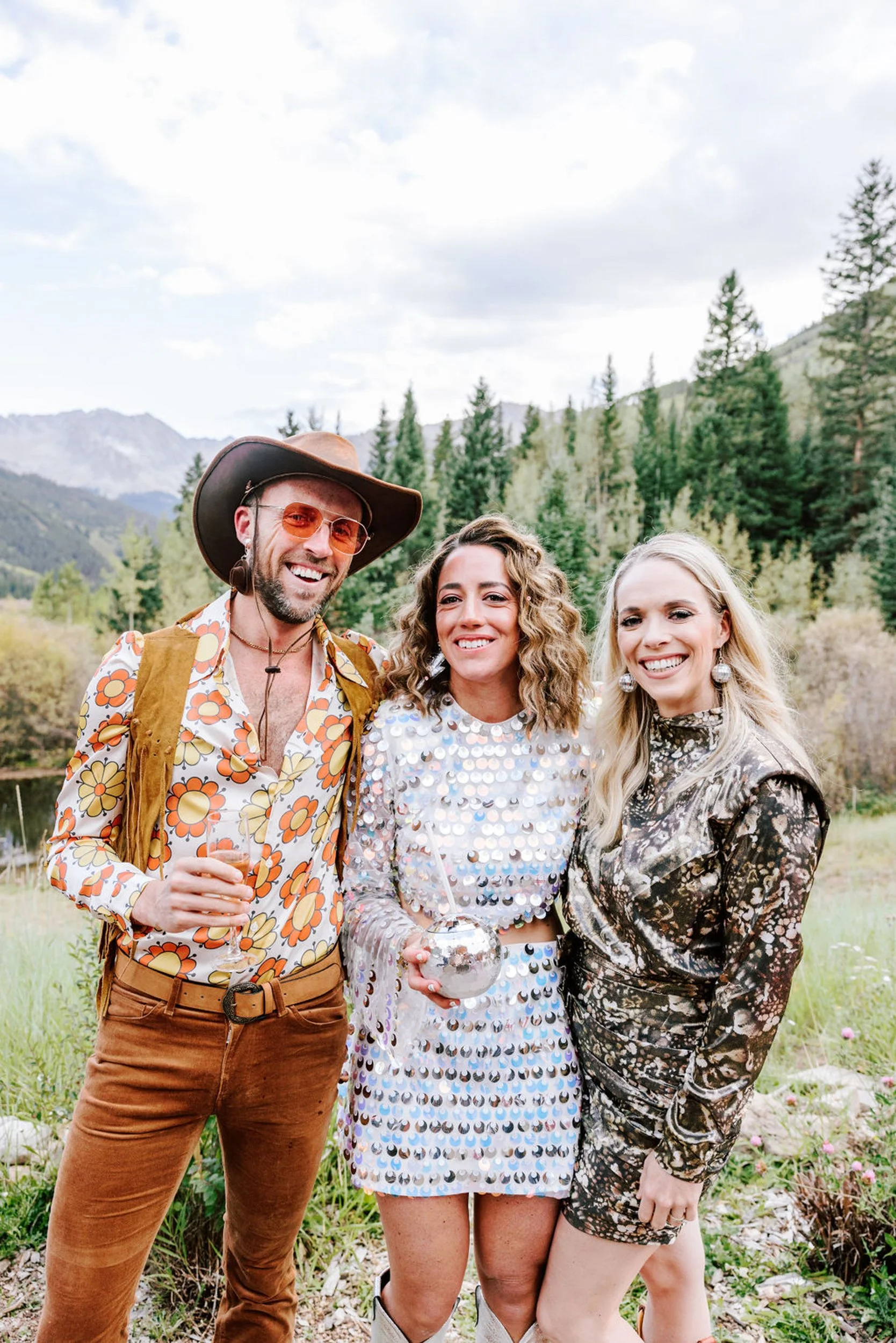 Wedding guests in floral western and boho outfits with Colorado mountain and pine tree backdrop at Pine Creek Cookhouse wedding in Aspen
