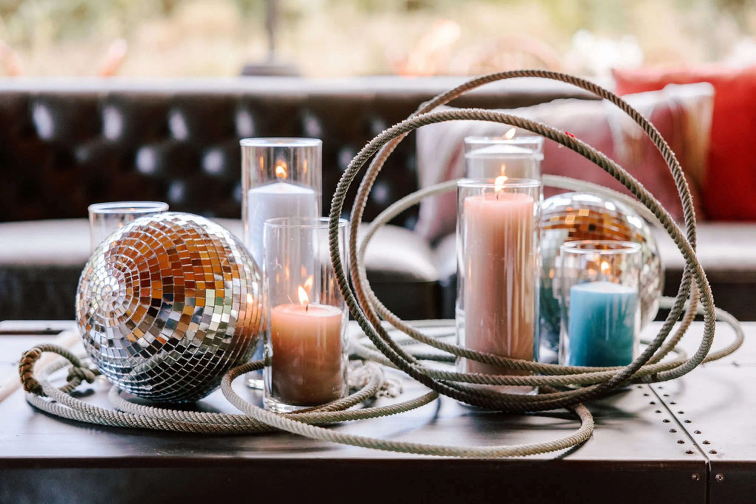 Wedding table centerpiece with disco ball, pillar candles, and coiled lasso rope, rodeo disco wedding reception detail at Pine Creek Cookhouse Aspen Colorado