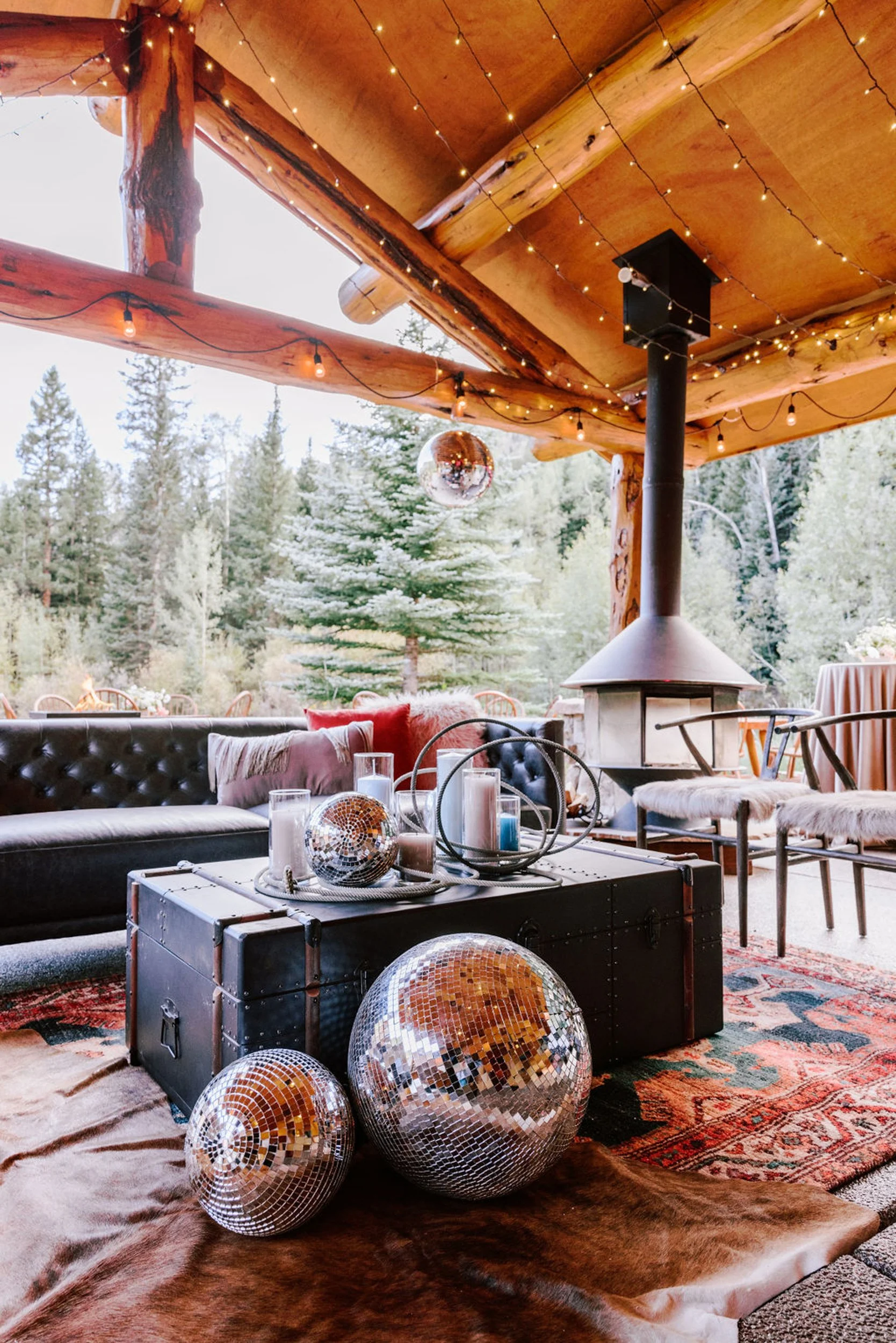 Pine Creek Cookhouse wedding reception with log timber rafters, pine tree views, and disco ball centerpieces on tables, Aspen Colorado mountain wedding venue interior