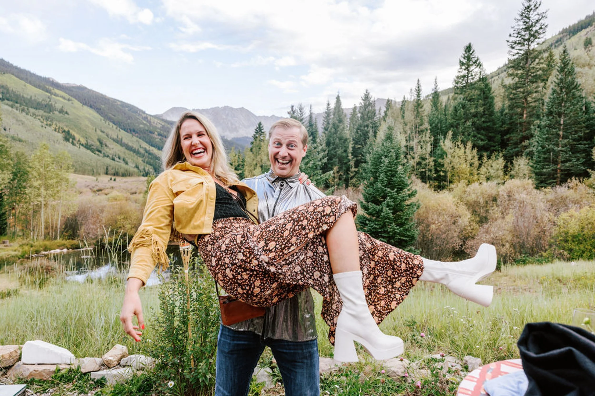 Wedding guests in western outfits celebrating in an Aspen mountain meadow at Pine Creek Cookhouse rodeo disco wedding in Colorado