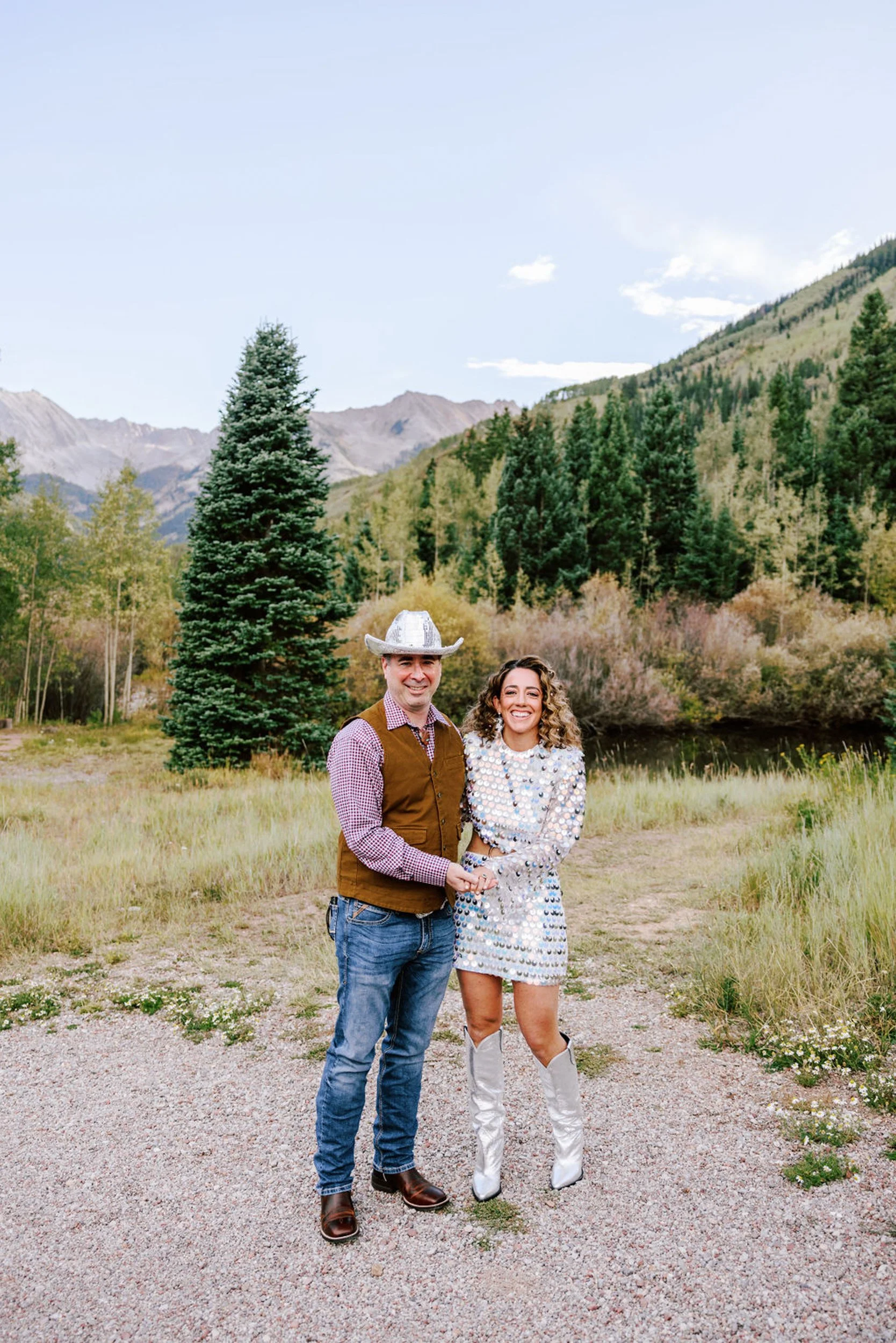 Bride and groom portrait on a pine-lined gravel path with Elk Mountains behind them, Pine Creek Cookhouse Aspen Colorado wedding photography