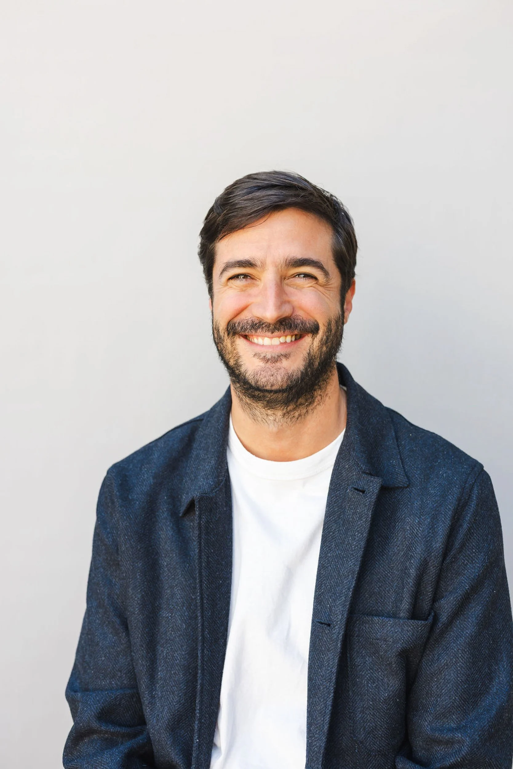 Corporate headshot of a man in a navy blazer photographed by Denver headshot photographer Betsi Ewing