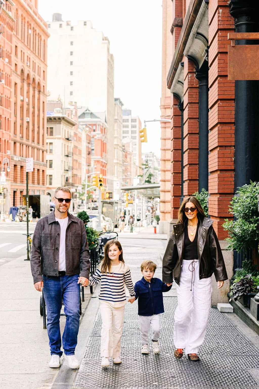 Family of four walking through a New York City neighborhood during an editorial family photoshoot by Betsi Ewing