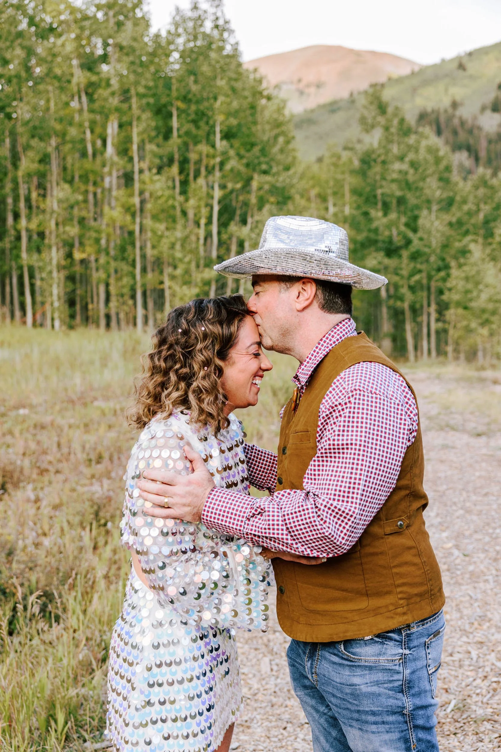 Bride and groom sharing a kiss surrounded by golden aspen trees and mountain peaks, Pine Creek Cookhouse Aspen area wedding photography by Betsi Ewing