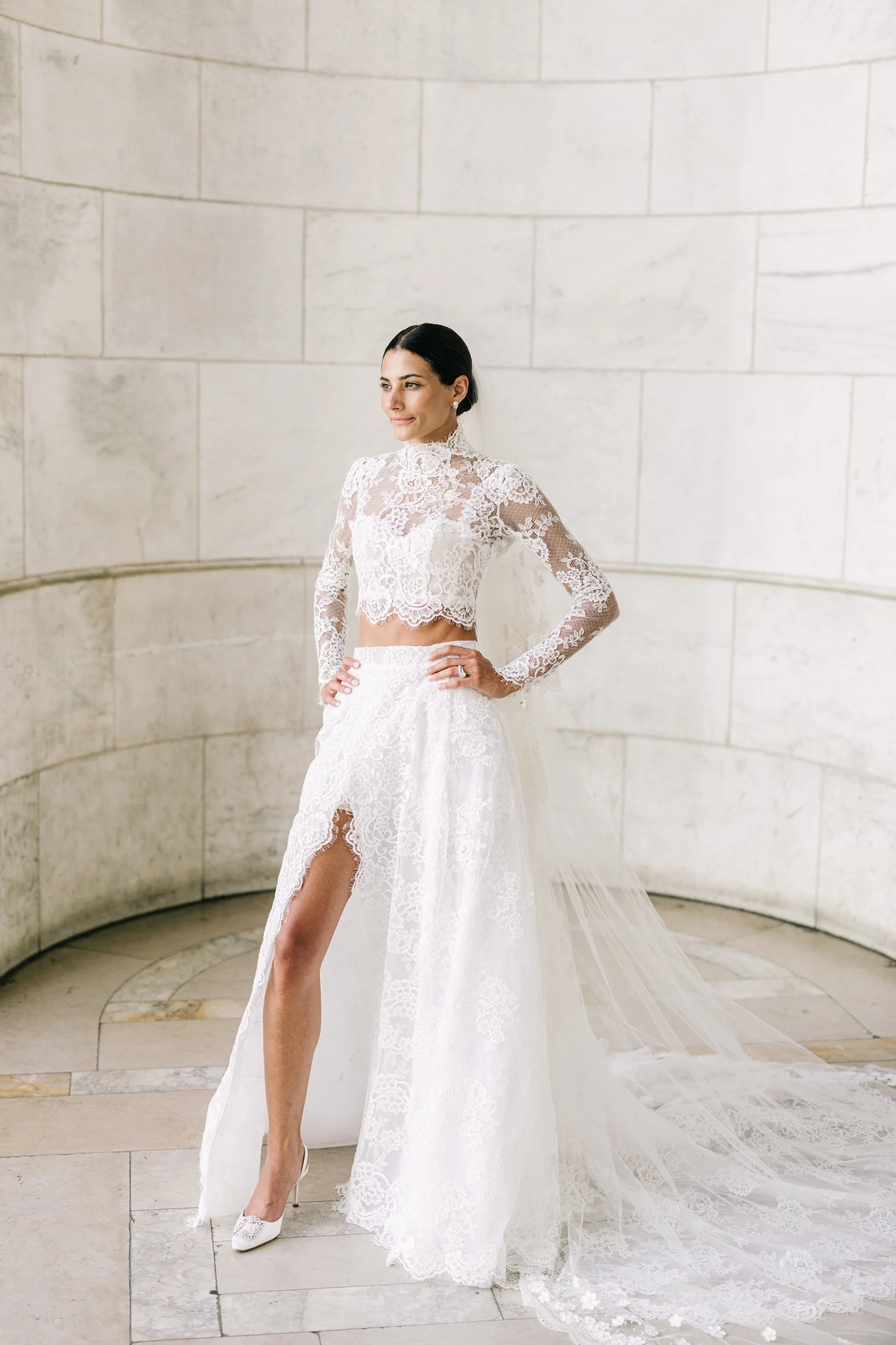 Bride posing confidently in a full-length bridal portrait in her lace gown at the New York Public Library, NYC wedding
