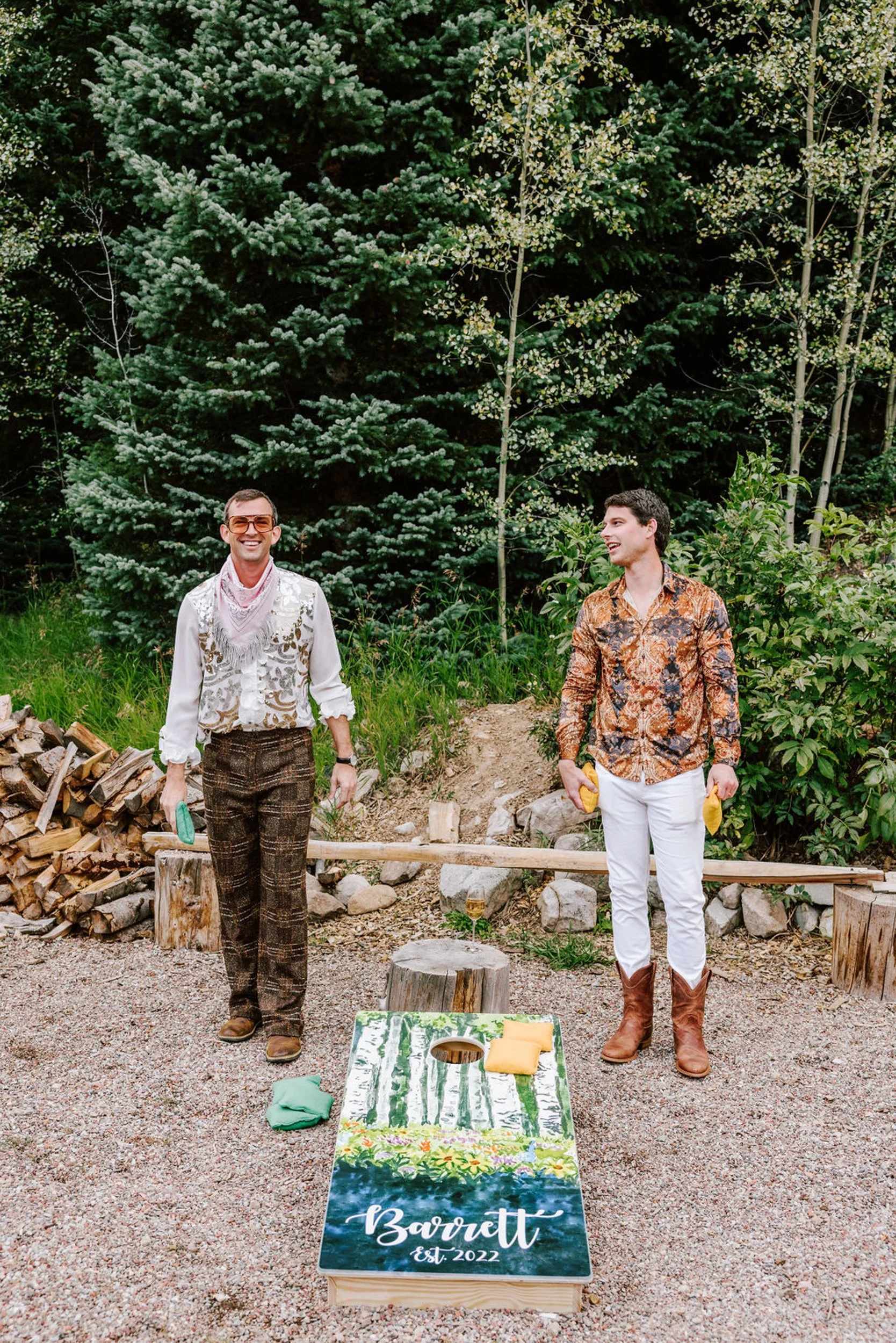 Wedding guests walking through pine trees arriving at Pine Creek Cookhouse rodeo disco reception in Aspen Colorado