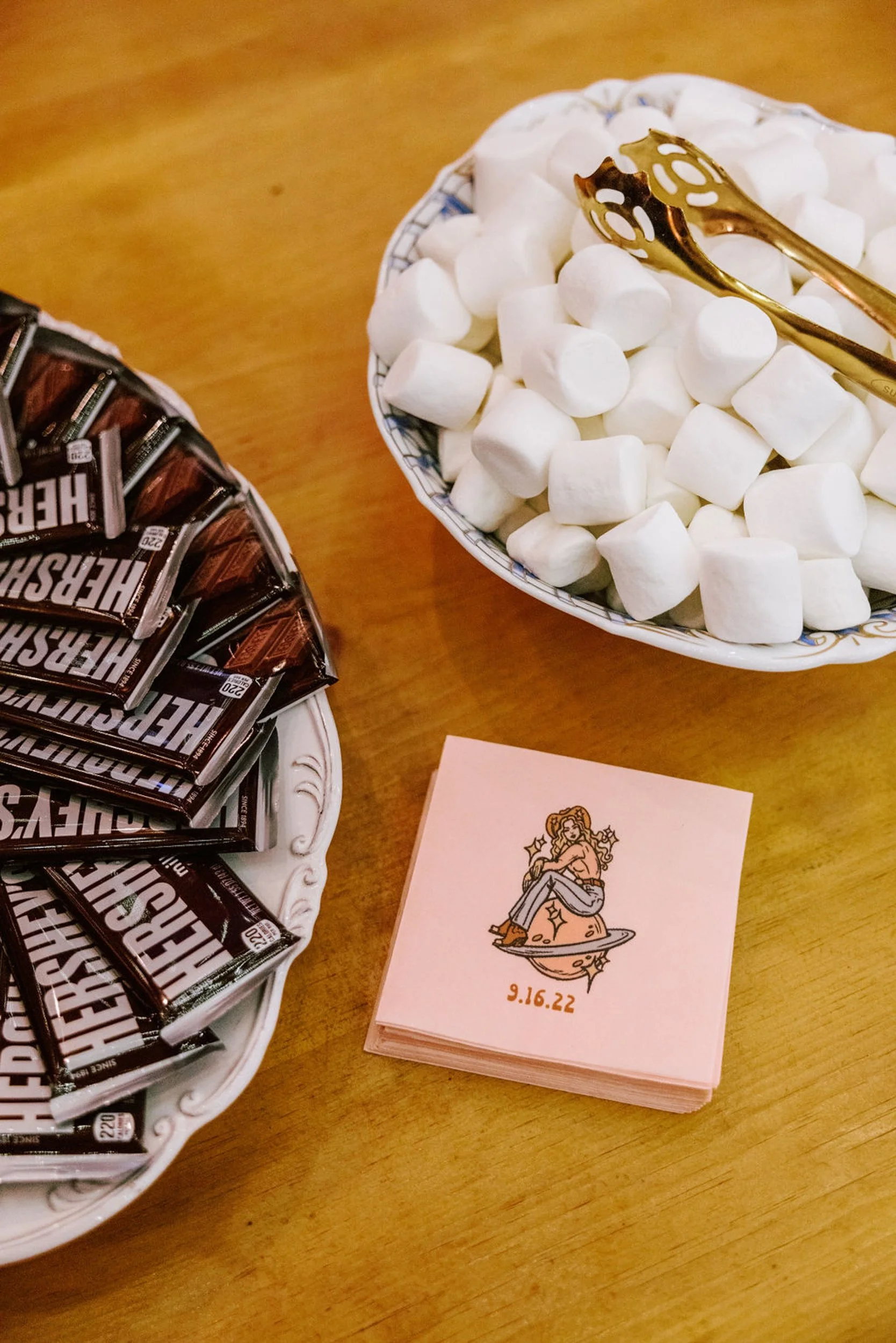 Wedding dessert station with Hershey's chocolate bars and marshmallows for s'mores alongside custom wedding napkins at Pine Creek Cookhouse reception