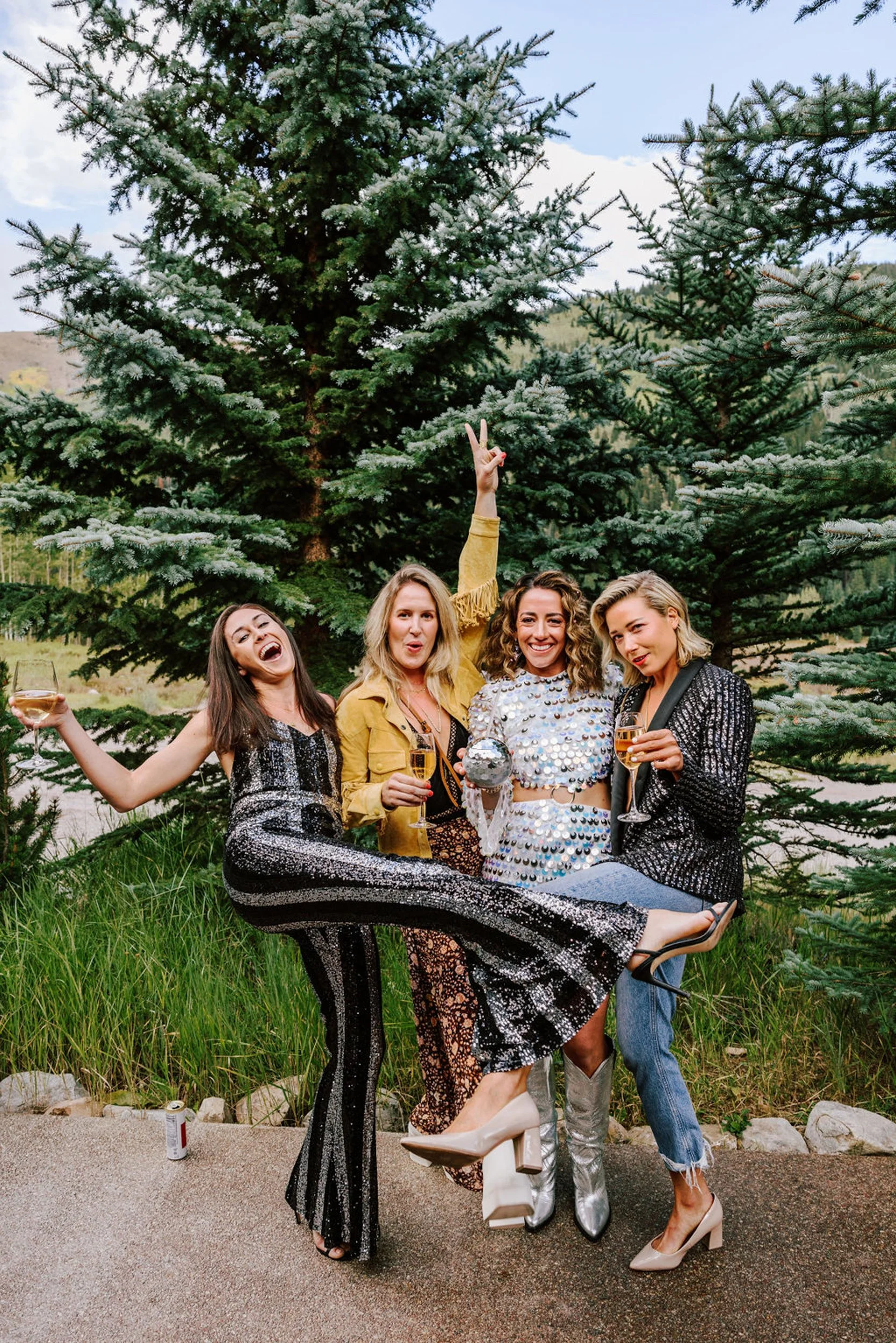 Bridesmaids in colorful western and boho outfits laughing together at Pine Creek Cookhouse rodeo disco wedding in Aspen Colorado