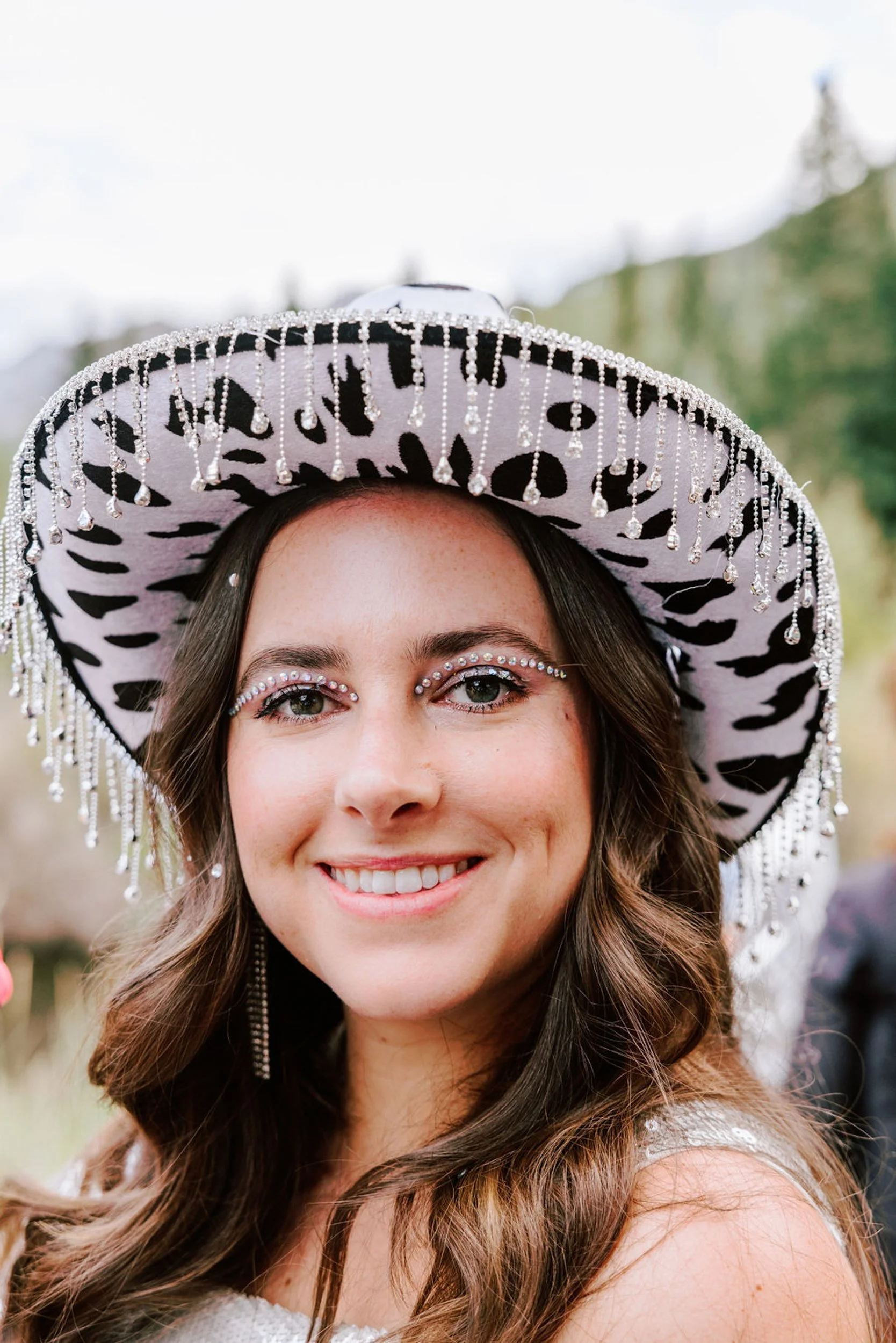 Wedding guest smiling in a large sombrero style hat, fun rodeo disco wedding guest portrait at Pine Creek Cookhouse in Aspen Colorado