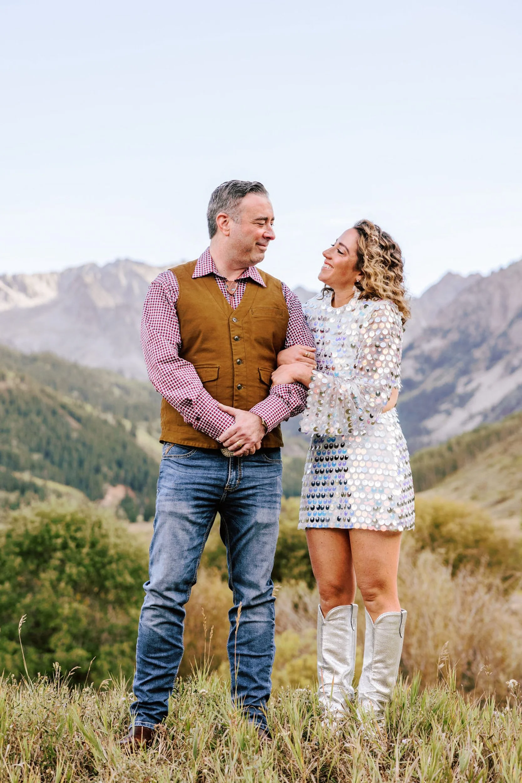Wedding couple smiling at each other with dramatic Elk Mountain peaks behind them, Pine Creek Cookhouse Aspen area wedding photography by Betsi Ewing
