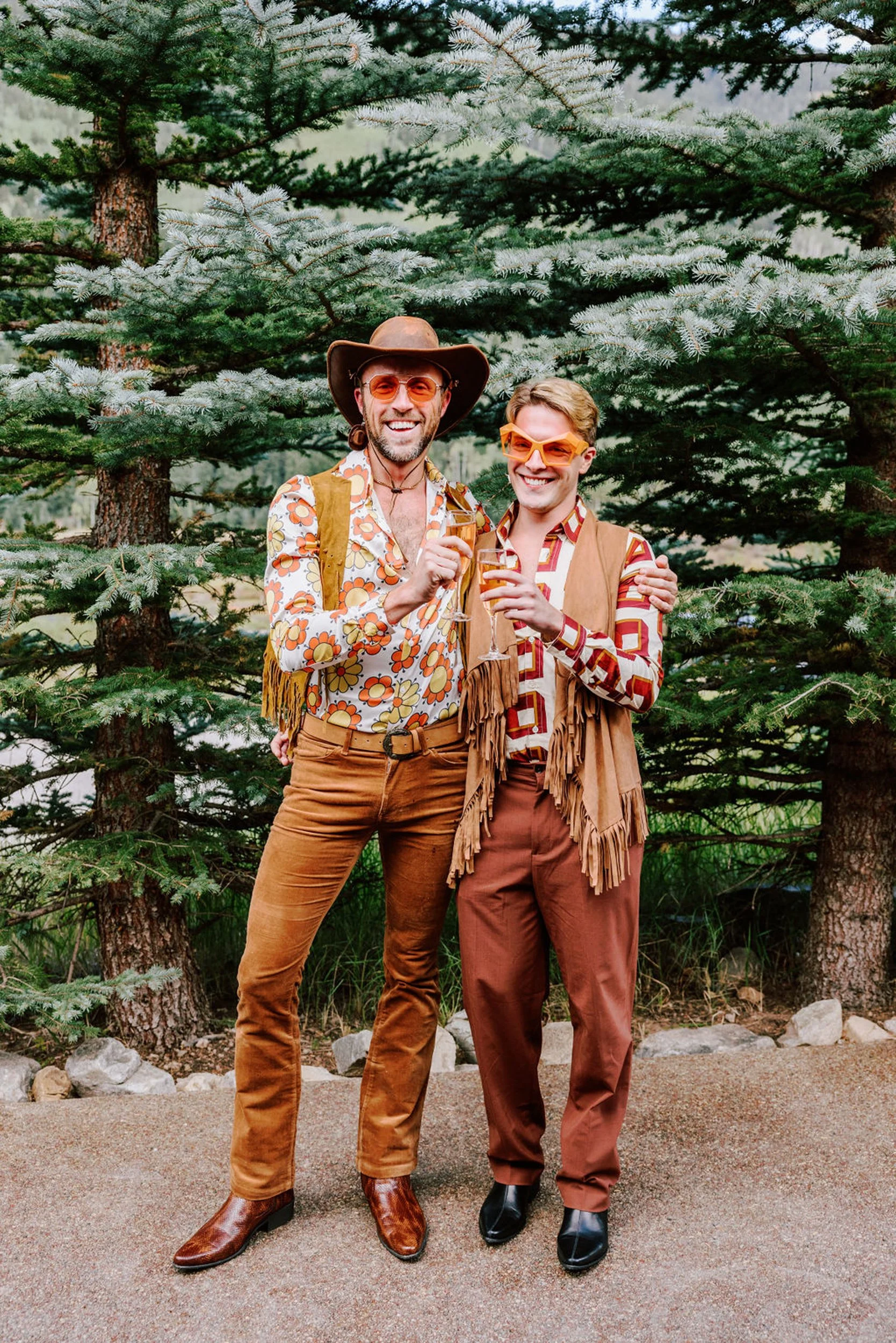 Groom and groomsmen in western fringe and floral outfits laughing together at Pine Creek Cookhouse rodeo disco wedding in Aspen Colorado
