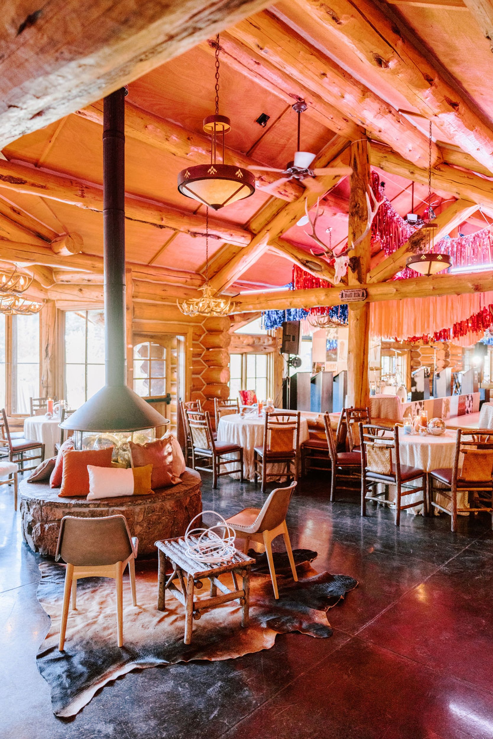 Pine Creek Cookhouse wedding reception interior with warm wood walls, dining tables set for guests, and disco ball decor, Aspen Colorado mountain wedding venue