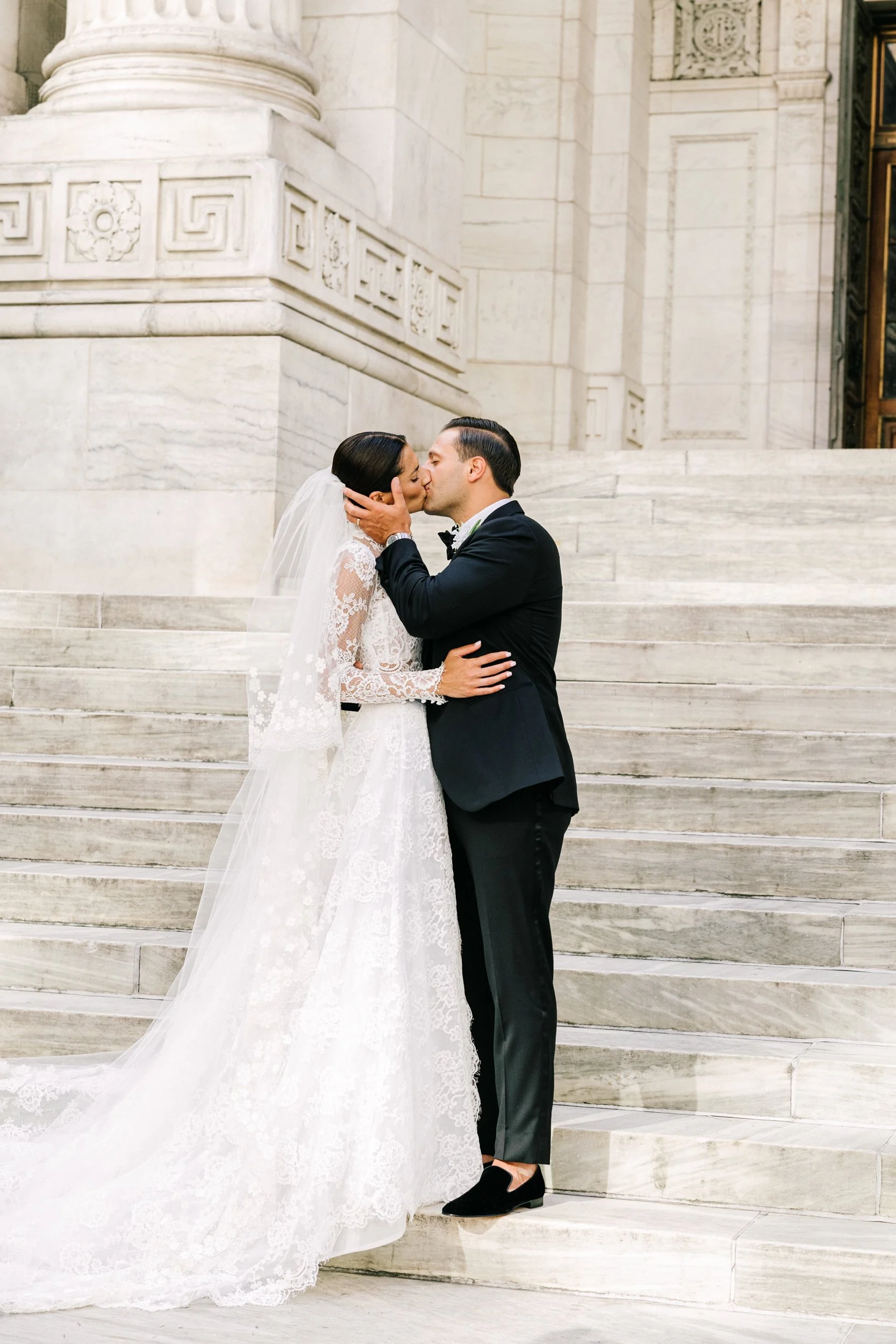 Bride and groom sharing a kiss on the grand steps of the New York Public Library, NYC wedding