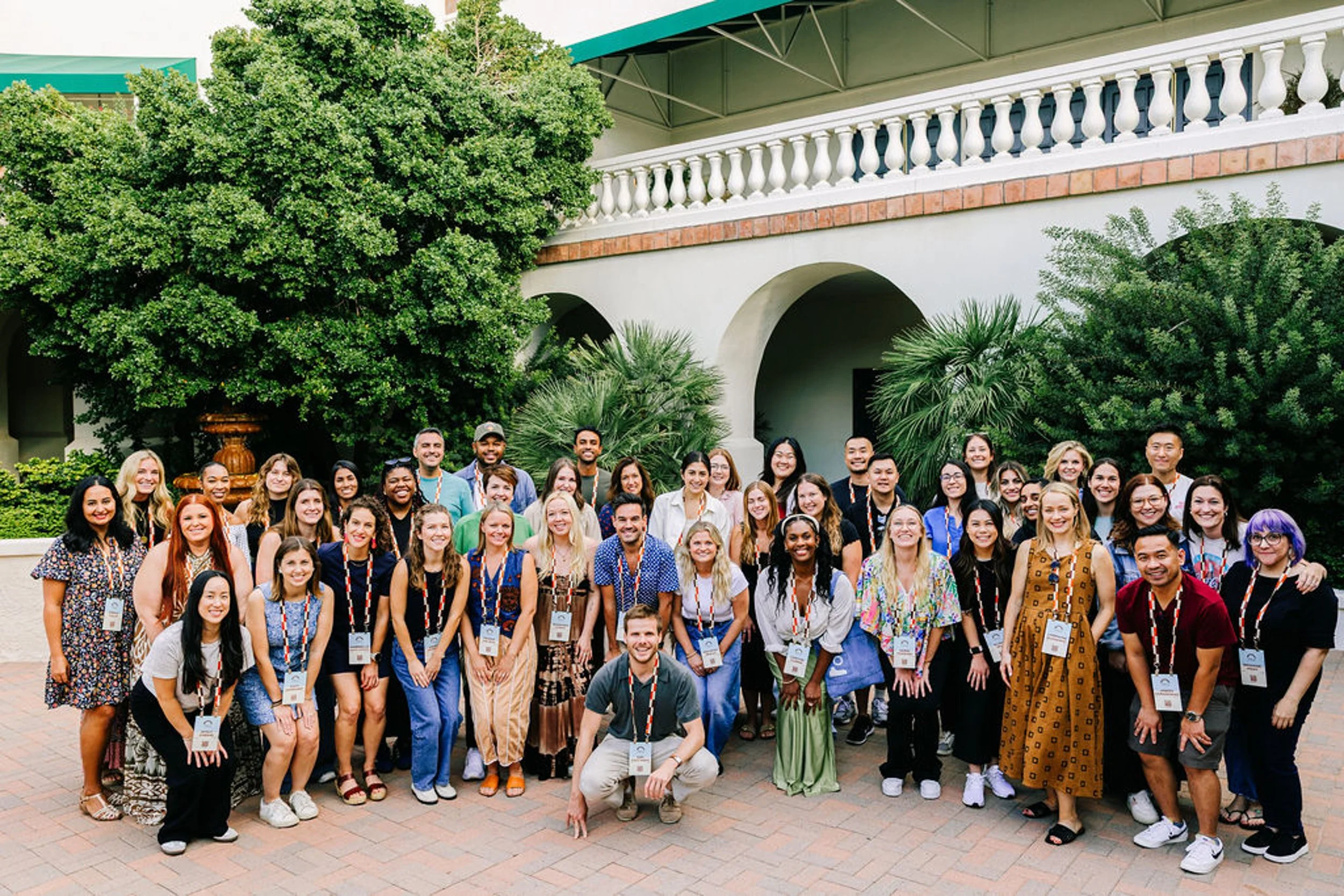 Large group photo at a garden venue during a corporate offsite event photographed by Betsi Ewing