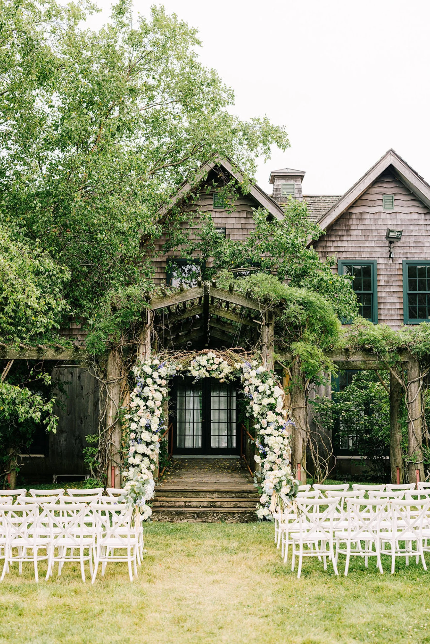 Outdoor ceremony setup with floral arch in the garden at Jedediah Hawkins Inn on Long Island's North Fork
