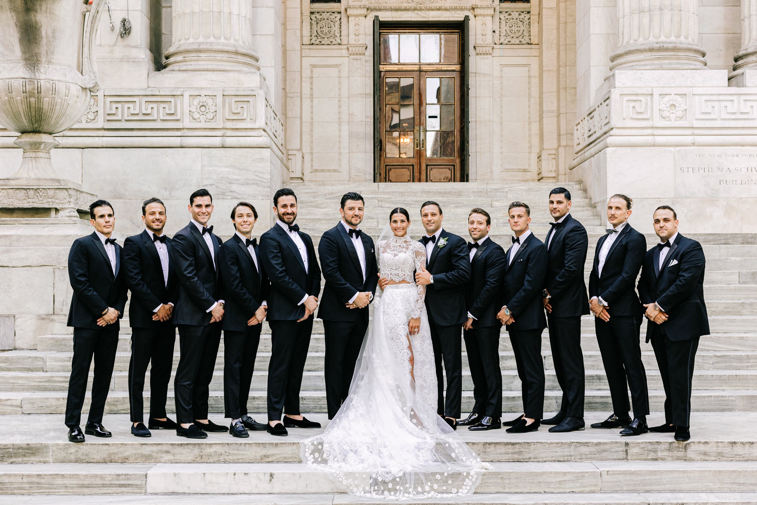Groom with his groomsmen in a classic group portrait on the steps of the New York Public Library, NYC wedding