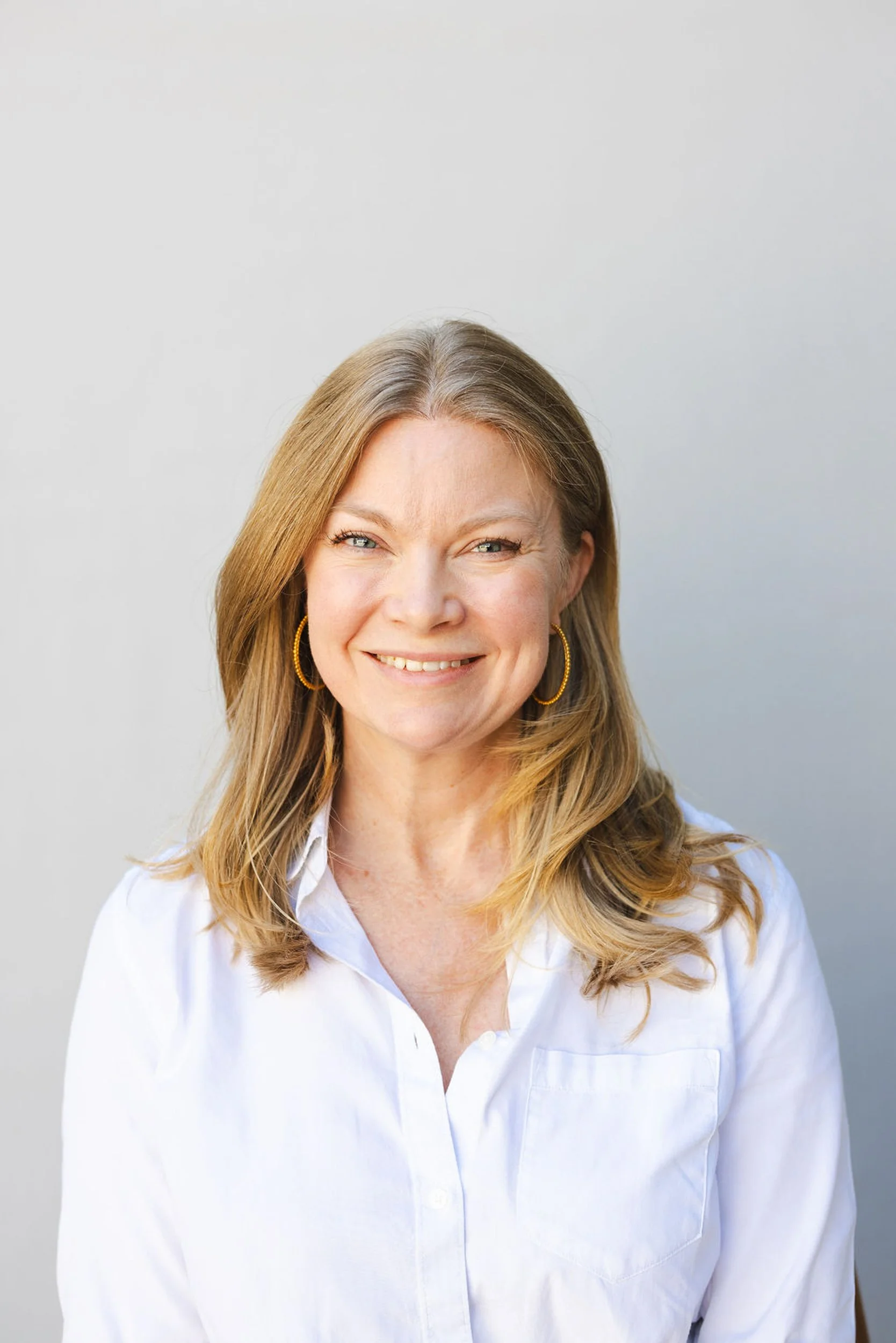 Professional business headshot of a blonde woman in a white blouse photographed in Denver by Betsi Ewing