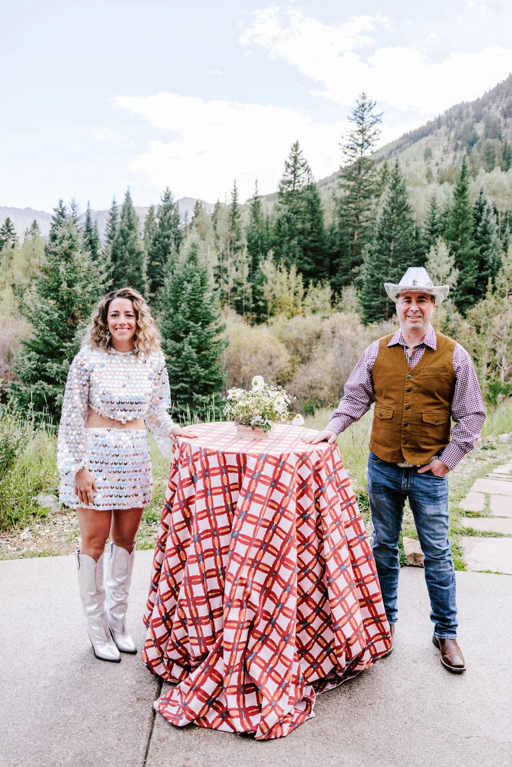 Bride and groom at a red and white checkered reception table at Pine Creek Cookhouse, rodeo disco themed wedding reception in the Colorado mountains