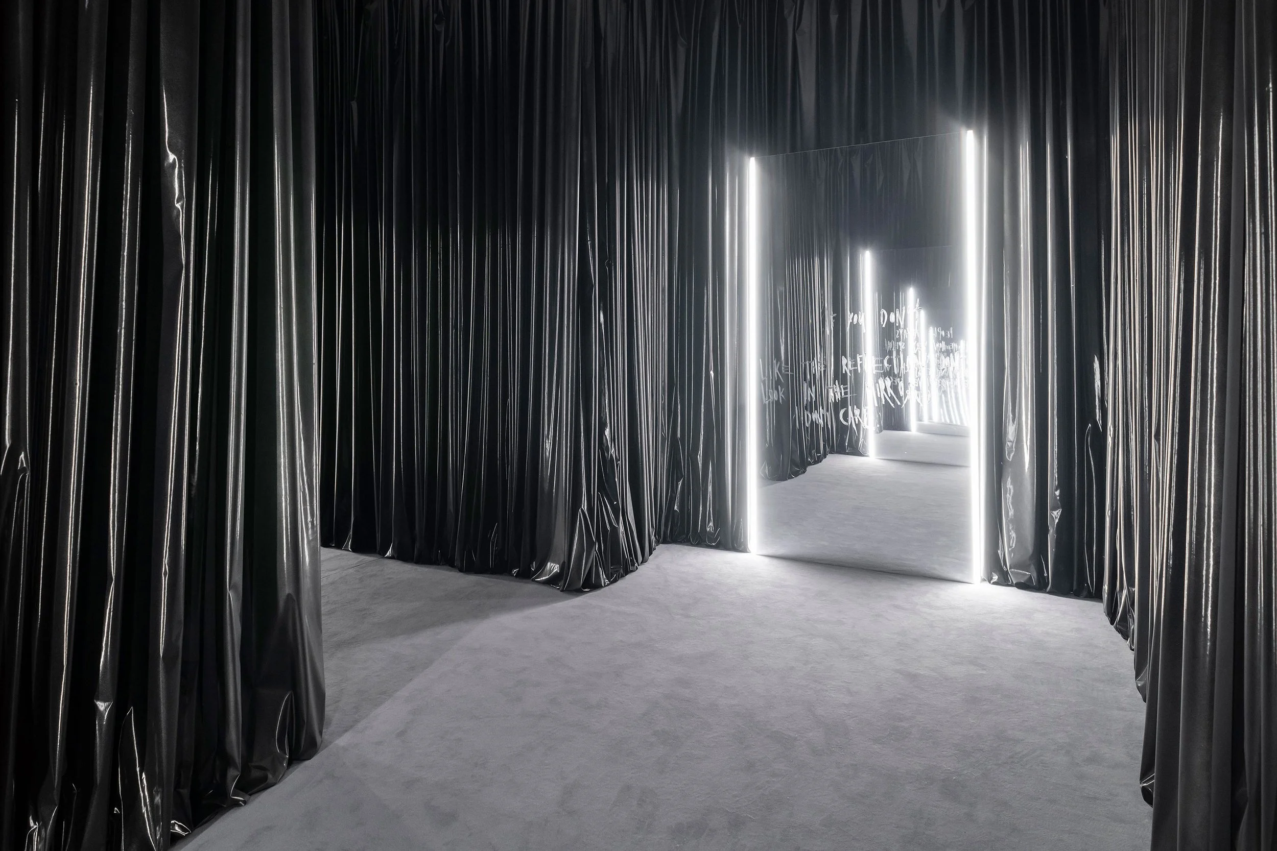 IF YOU DON'T LIKE THE REFLECTION.
DON'T LOOK IN THE MIRROR. 
I DON'T CARE. (LUKA), 2022
Mirror foil on alu-frame, lipstick, 
LED lights, metal lacquer on vinyl 
curtain
Mirror: 298 x 156 x 4 cm; 
Curtain: variable dimensions