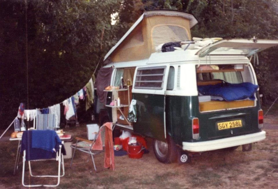 Vintage VW T2 Campervan, in full chaotic family camping mode with clothes hanging everywhere.