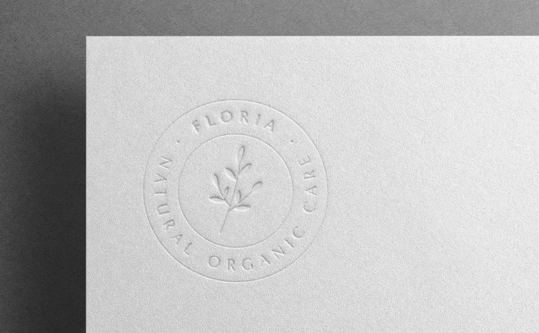 FLORIA Logo als Blindprägung auf weißem Papier im Rahmen des Brand Designs