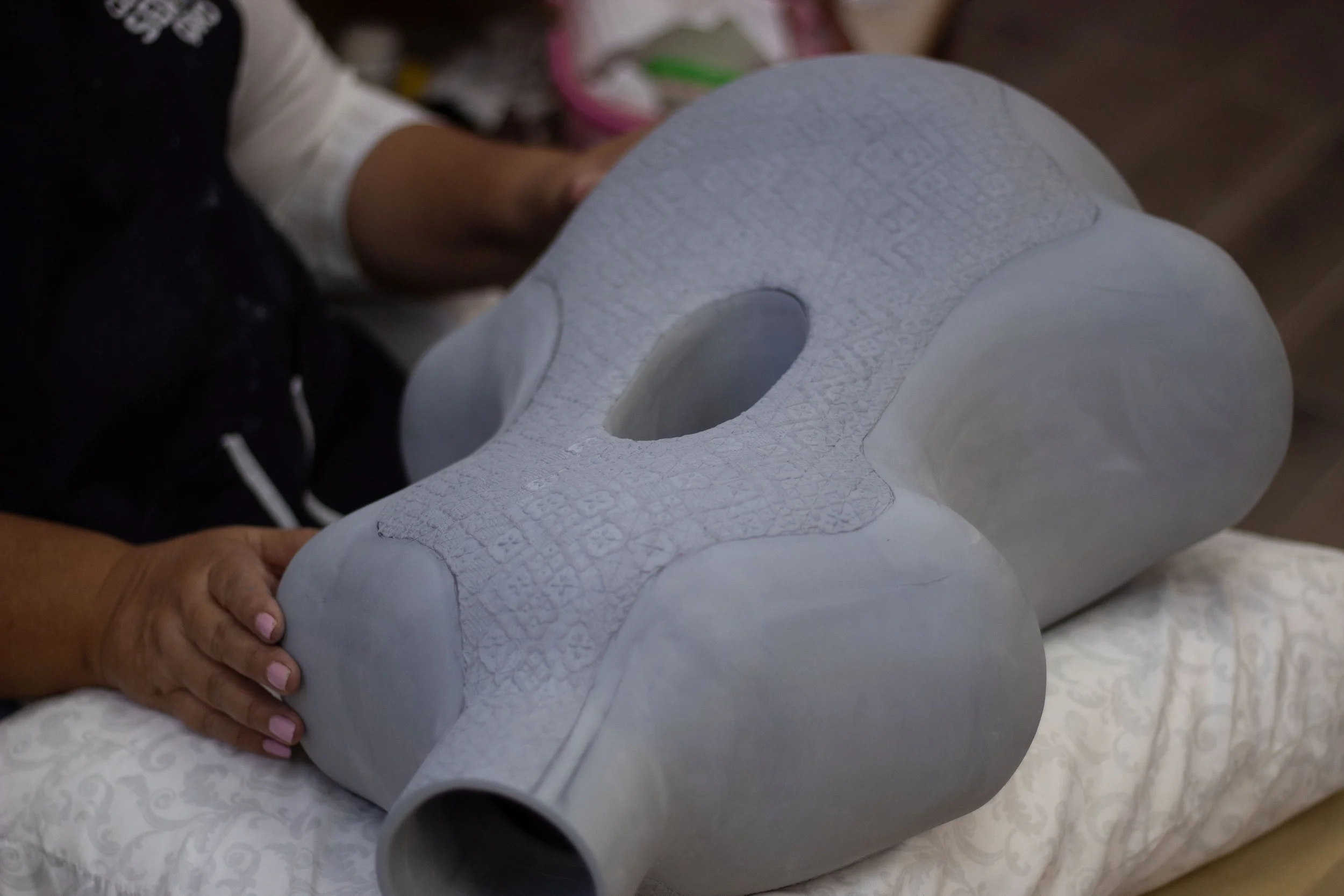 Eva Servin sosteniendo una escultura de cerámica, en proceso de creación.