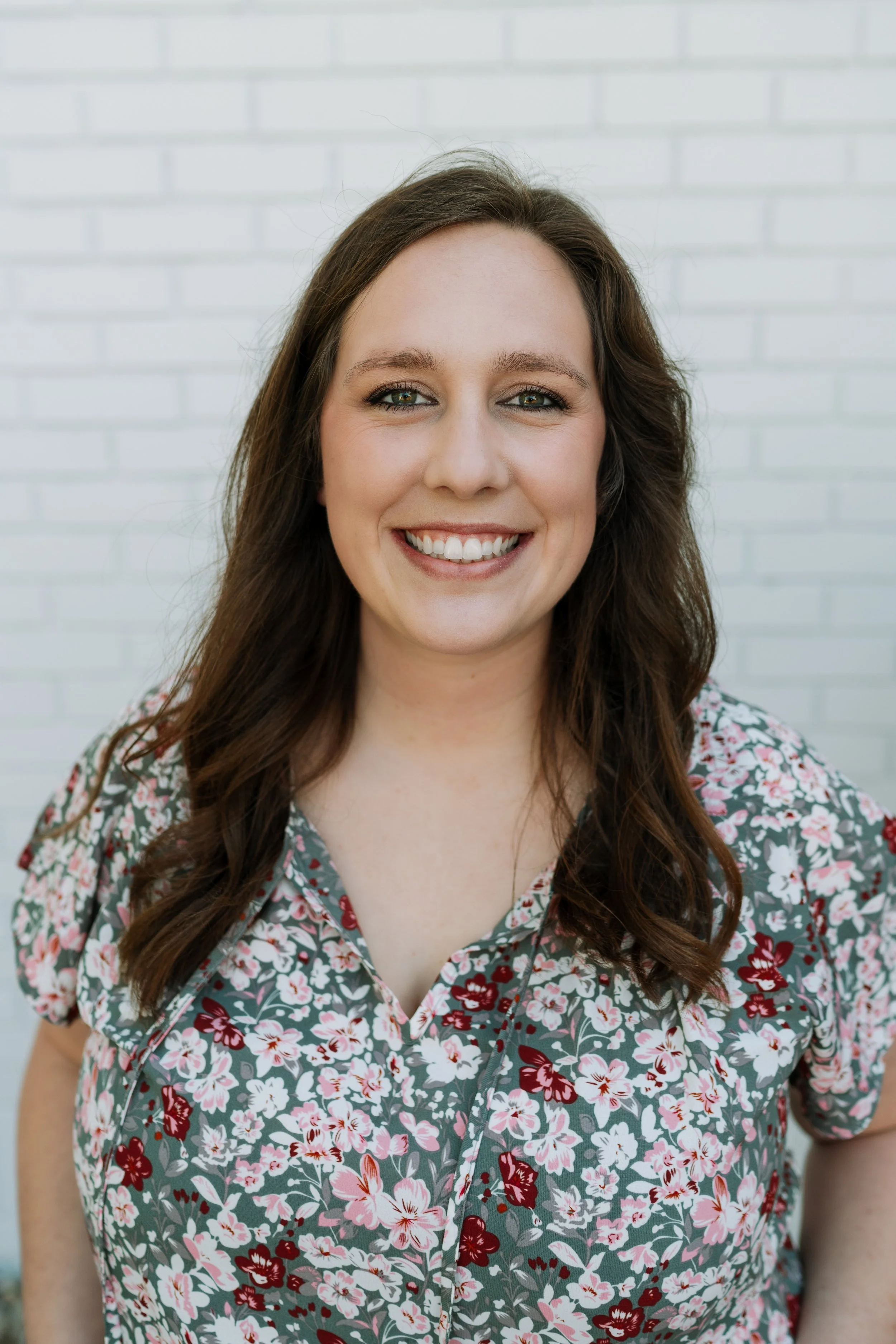 Hannah is a woman with dark blonde hair in an olive sweater