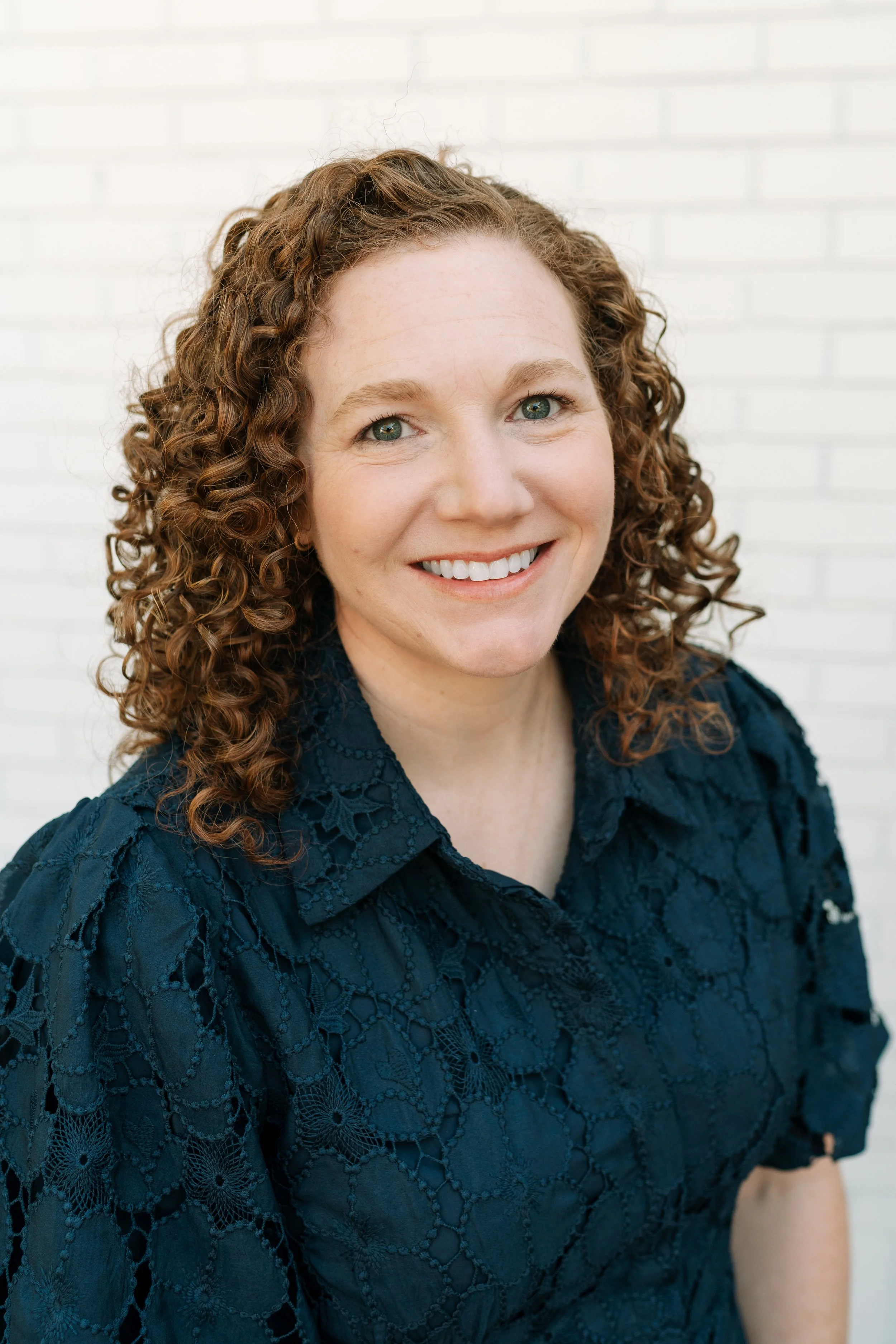 Dr. Meredith is a woman with red hair in a camel sweater