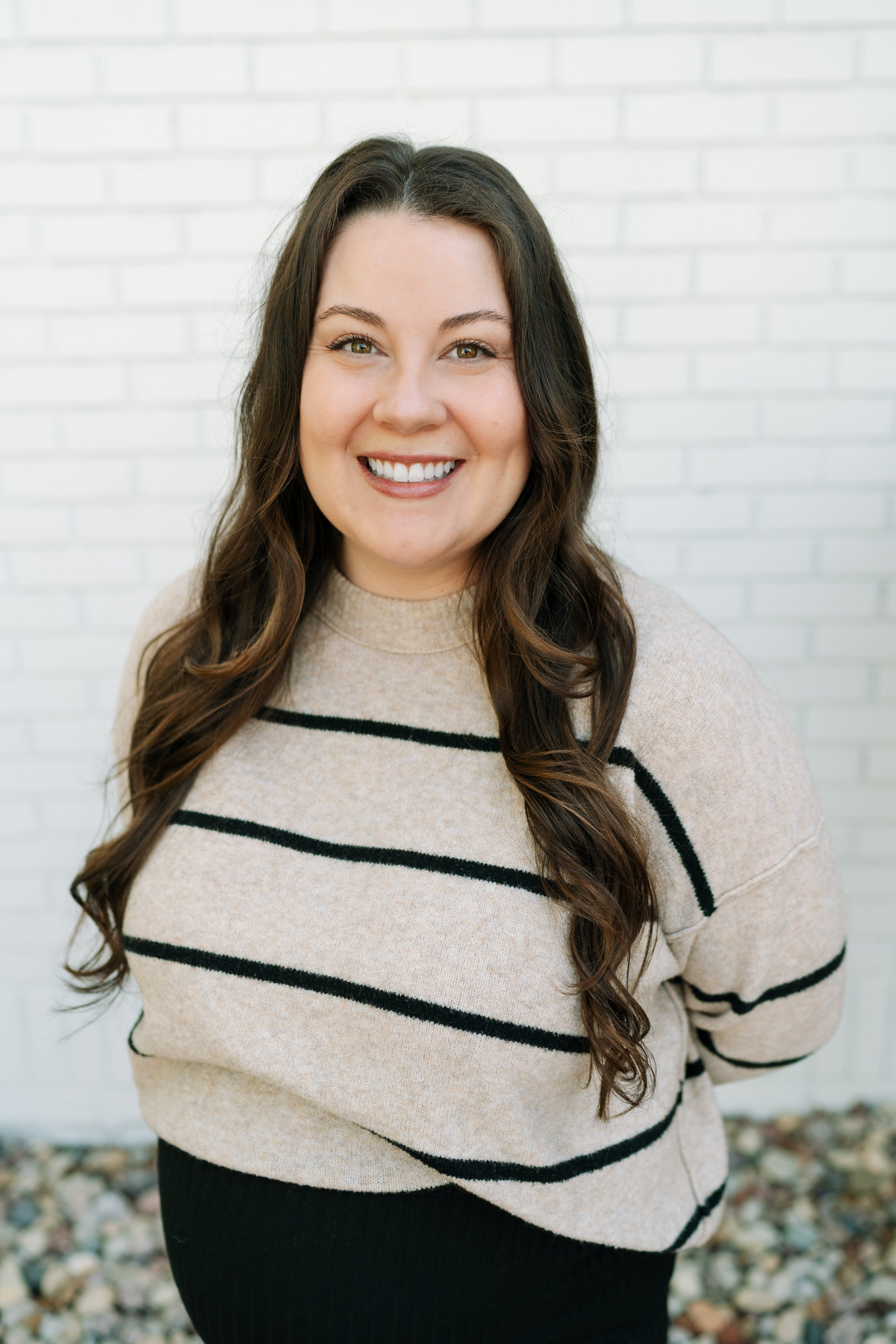 Catie is a woman with long dark hair in a brown sweater