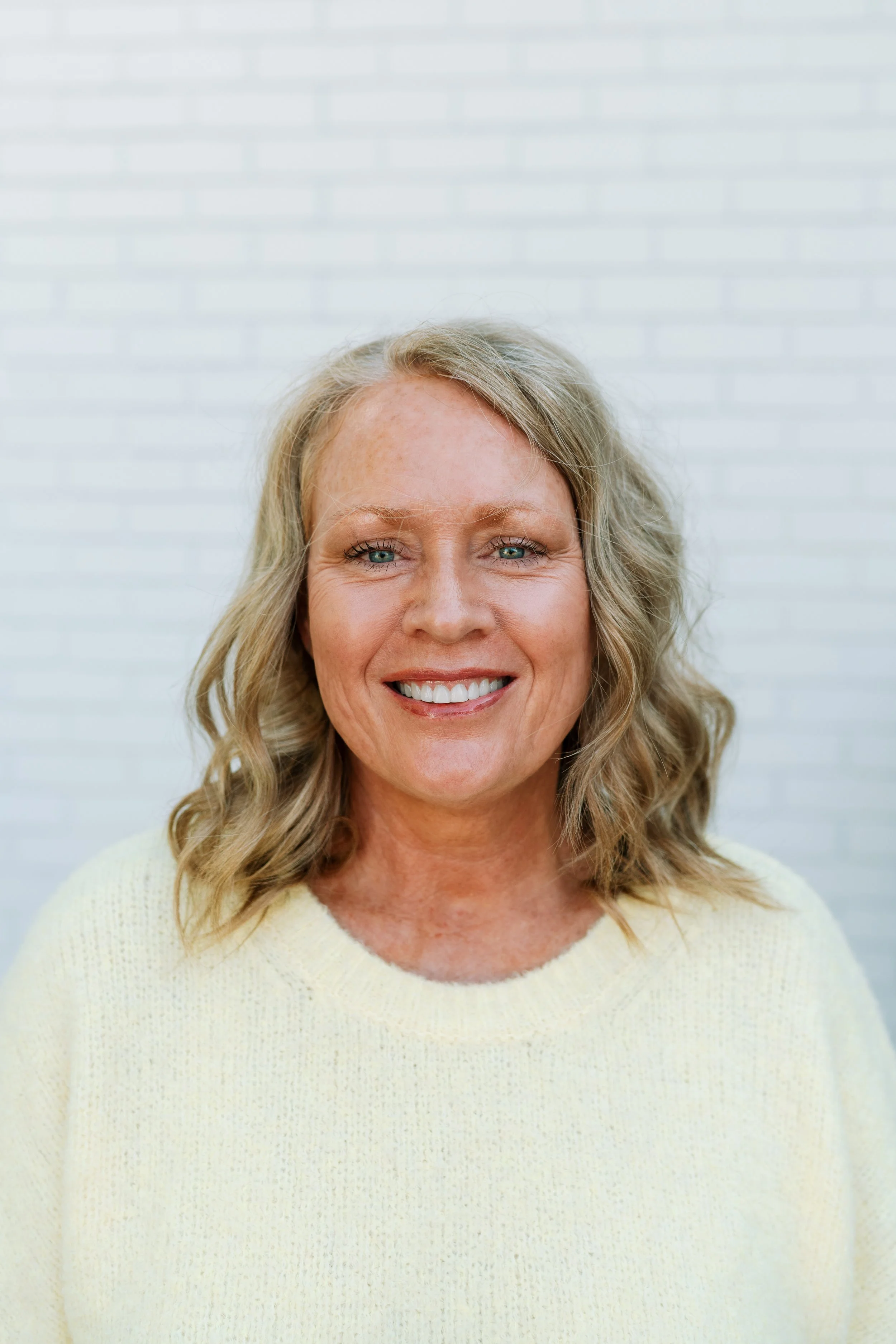 Dawn is a woman with long blonde hair in a dark green top